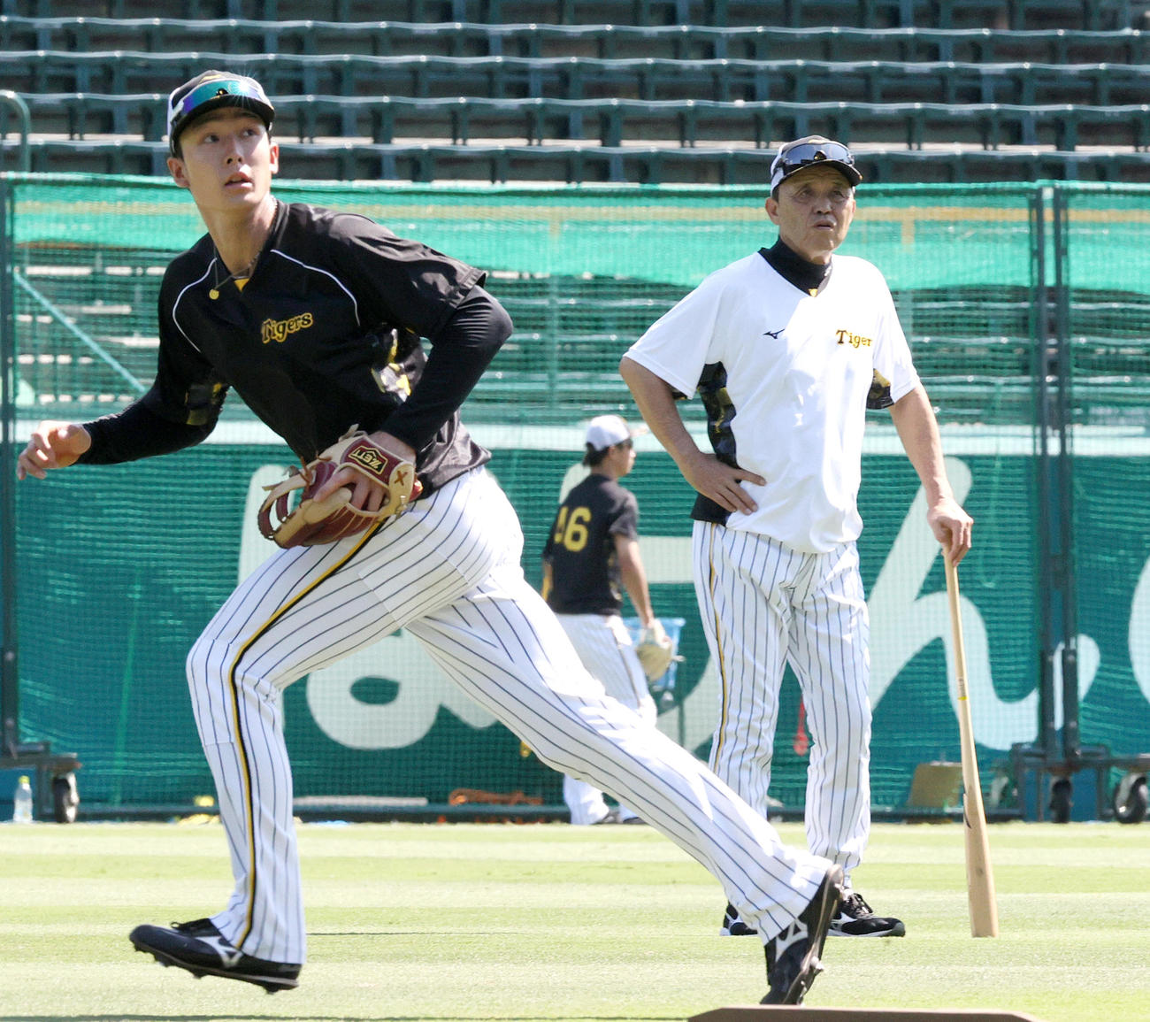 阪神対中日　試合前の練習でノックを受ける阪神小幡（手前）を見つめる岡田監督（撮影・上山淳一）