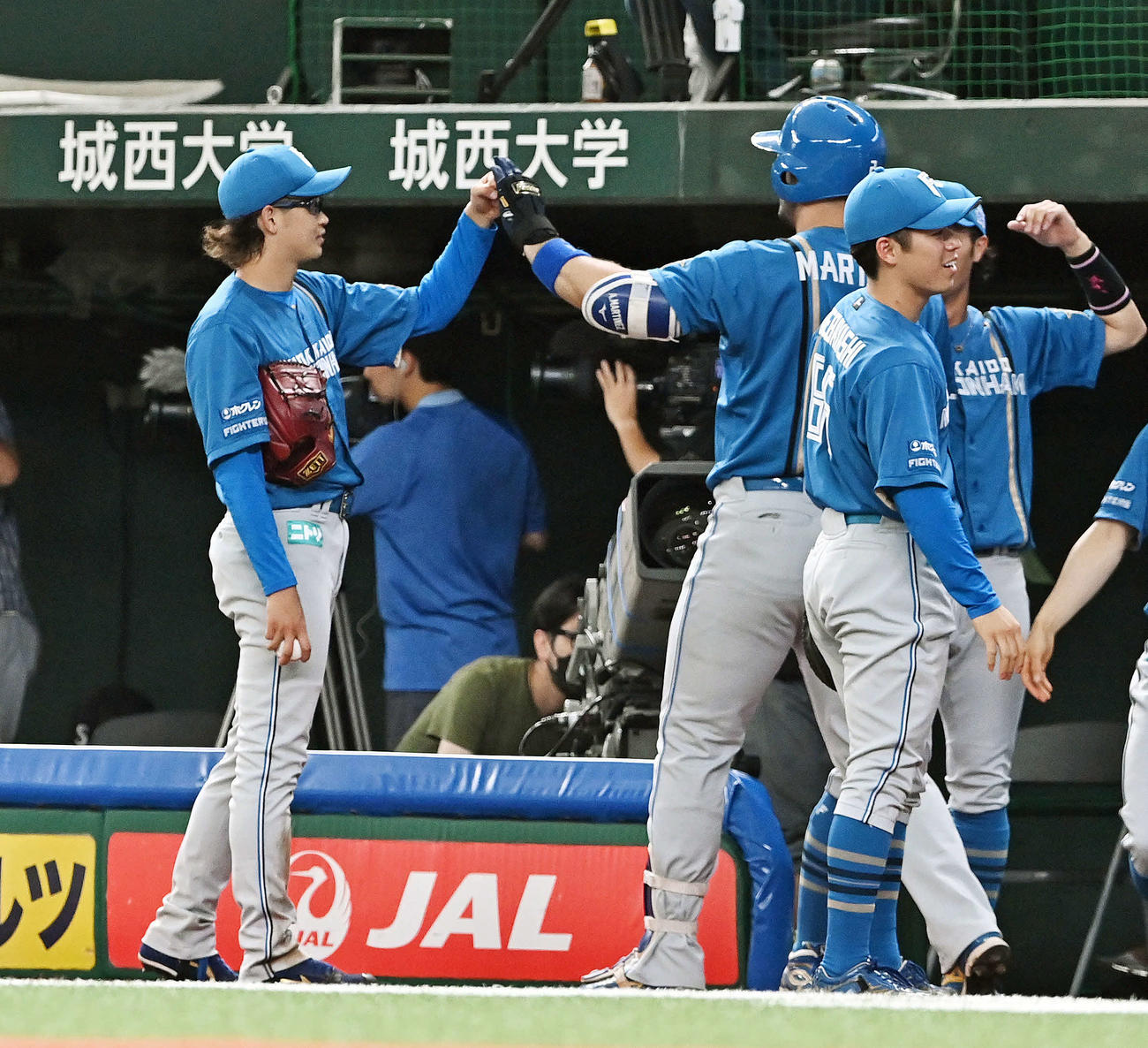 西武対日本ハム　1回表日本ハム1死一塁、鈴木（左）は先制2点本塁打を放ったマルティネスとタッチをかわす（撮影・滝沢徹郎）