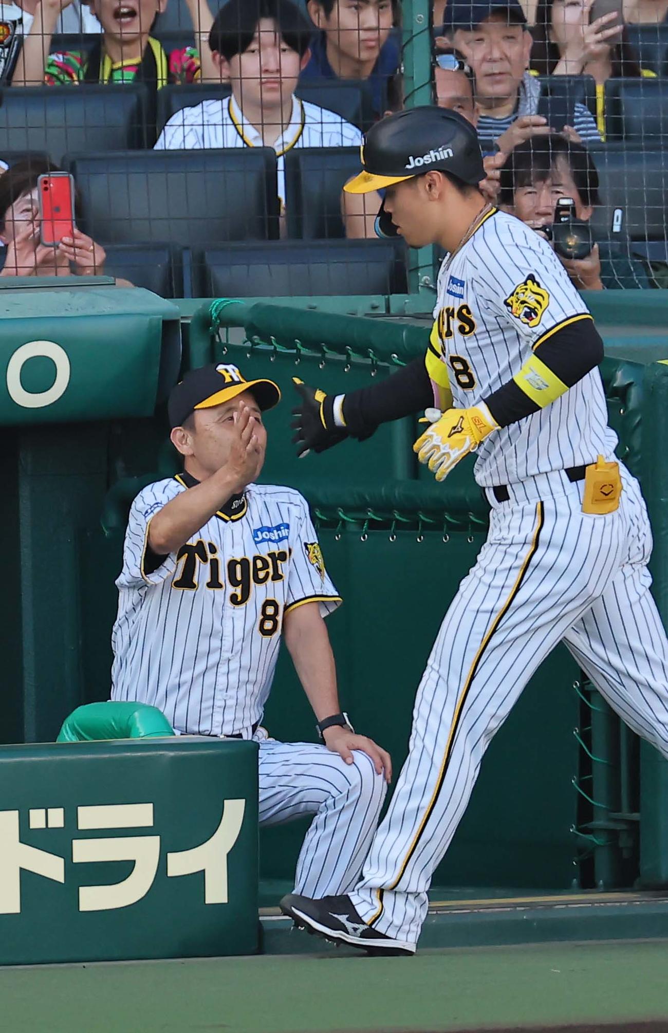 阪神対中日　1回裏阪神2死一、二塁、右中間へ3点本塁打を放った佐藤輝をベンチで出迎える岡田監督（撮影・上田博志）