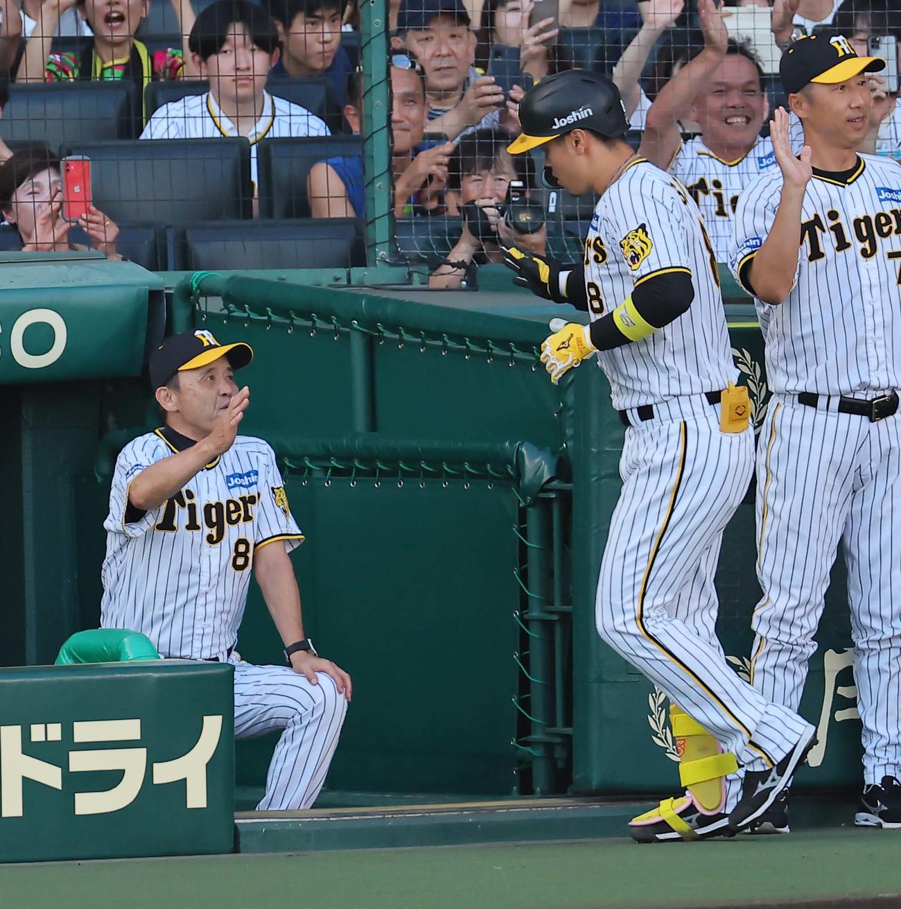 阪神対中日　1回裏阪神2死一、二塁、右中間へ3点本塁打を放った佐藤輝をベンチで出迎える岡田監督（撮影・上田博志）