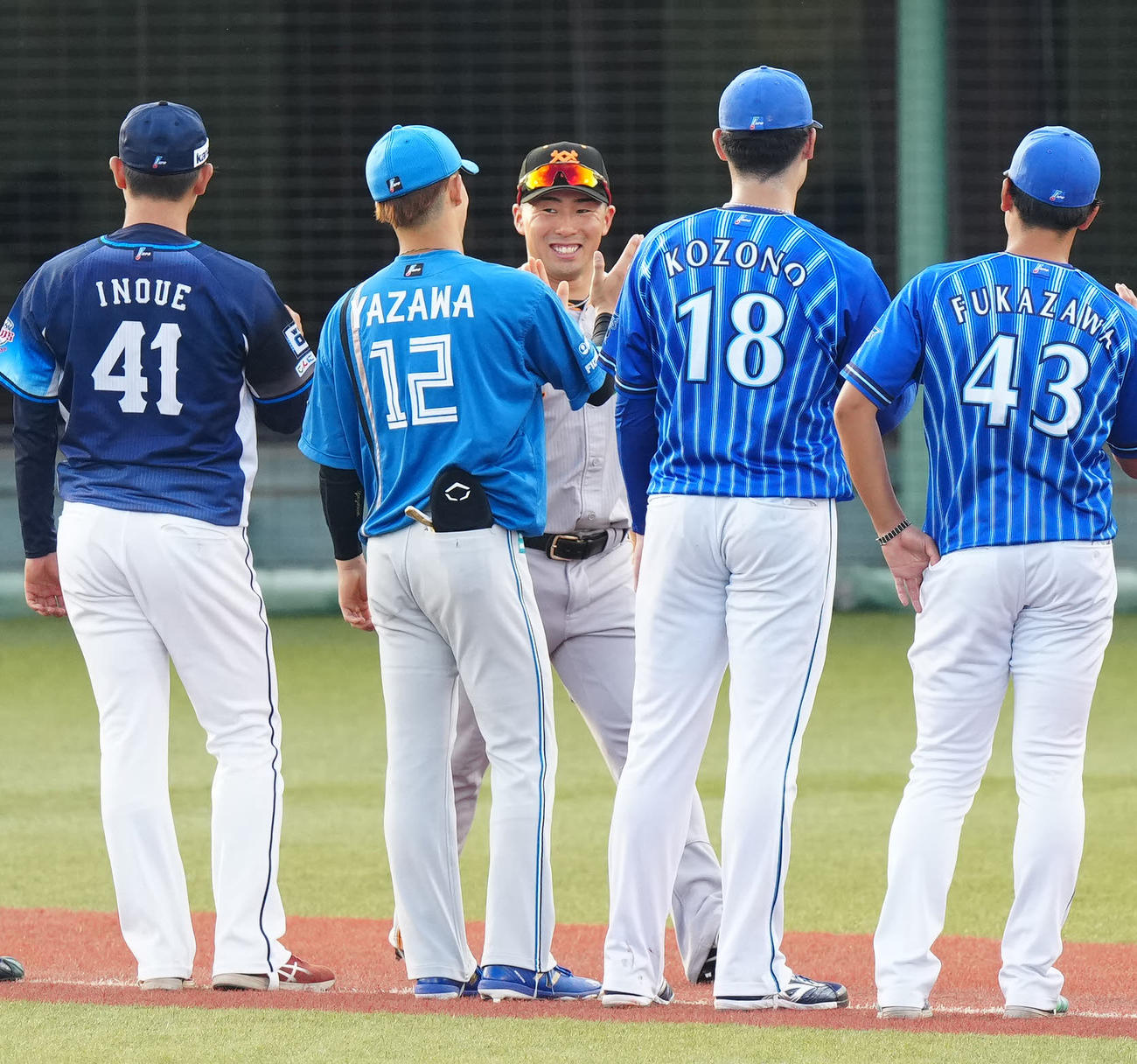 全ウ対全イ　試合前、選手紹介で登場し、全イの日本ハム矢沢（左から2人目）とタッチを交わす巨人浅野（撮影・江口和貴）