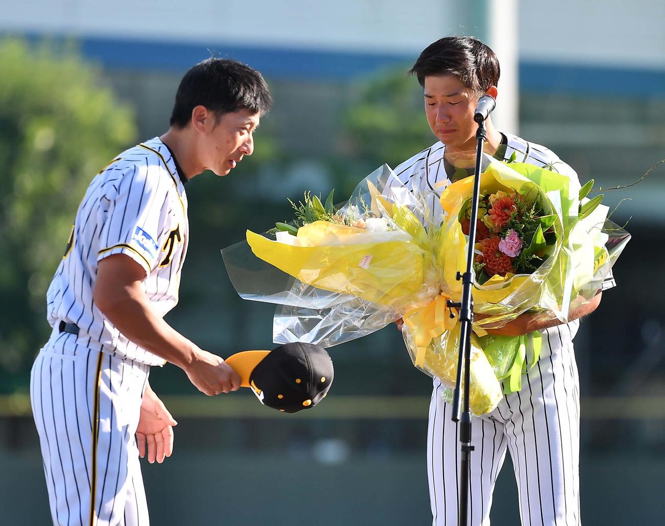 引退セレモニーで矢野監督（左）から花束を受け取る横田慎太郎さん（19年9月26日撮影）