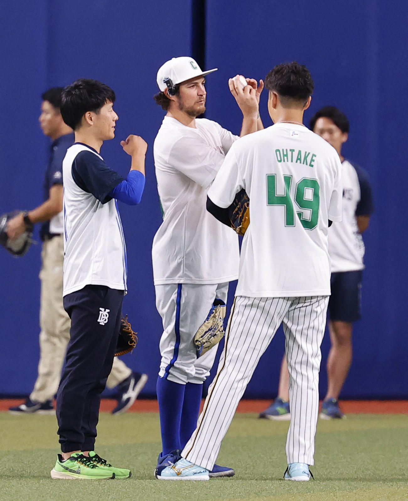 全セ対全パ　阪神大竹（右）に握りを教えるDeNAバウアー（中央）（撮影・藤尾明華）