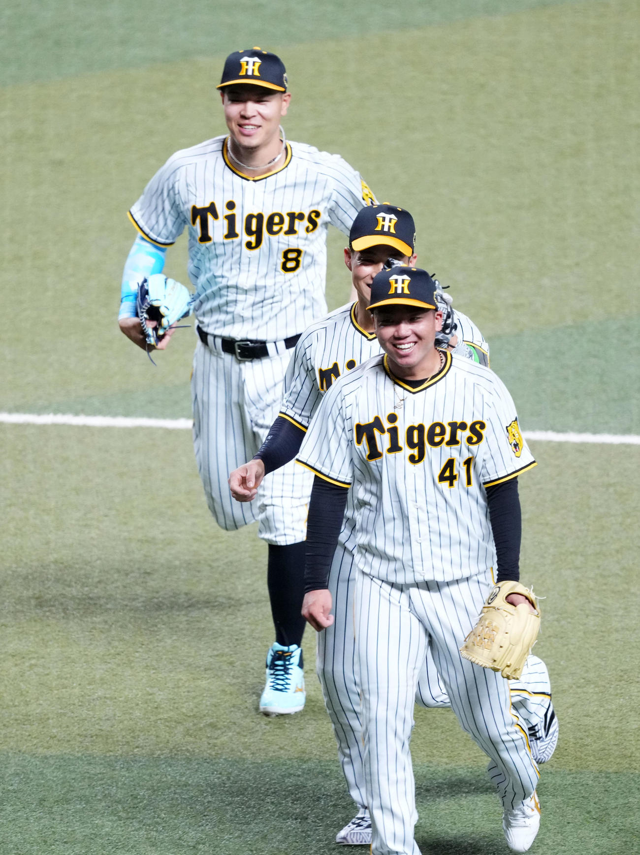 全セ対全パ　1回表を終え、全セ木浪（中央）に頭をたたかれ笑顔を見せる村上。左は佐藤輝（撮影・横山健太）