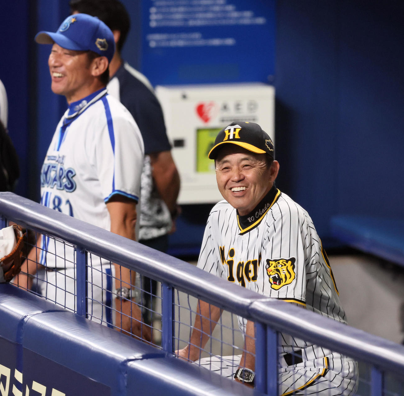 全セ対全パ　ベンチで笑顔を見せる岡田コーチ。左は三浦コーチ（撮影・加藤哉）
