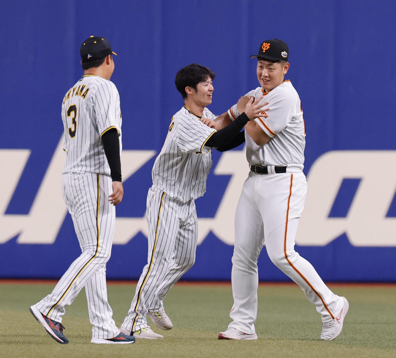 全セ対全パ　じゃれ合う阪神中野（中央）と巨人岡本和（撮影・藤尾明華）