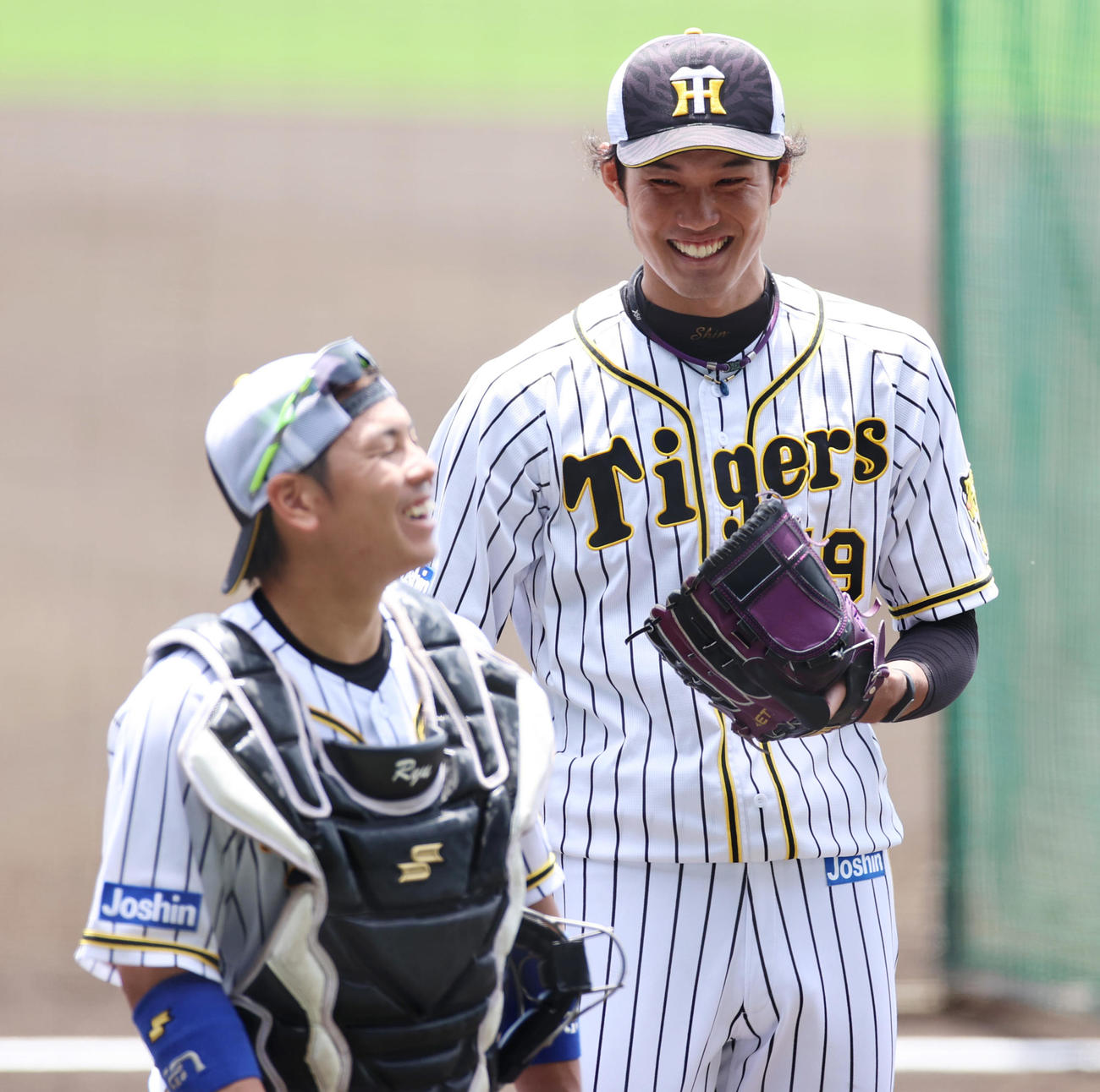 投内連係を終え笑顔で話し合う藤浪（右）と梅野（2021年6月17日撮影）