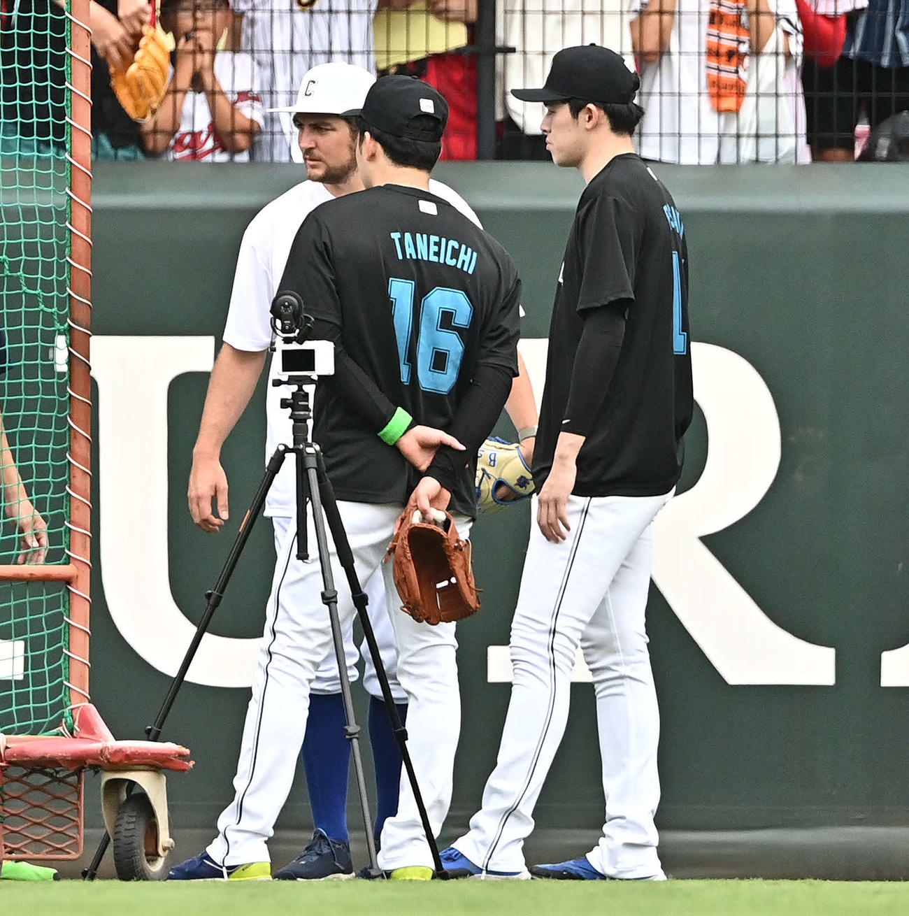 全セ対全パ　試合前練習で全セバウアー（後方）の話しを聞く全パ種市（手前左）と佐々木朗（撮影・滝沢徹郎）