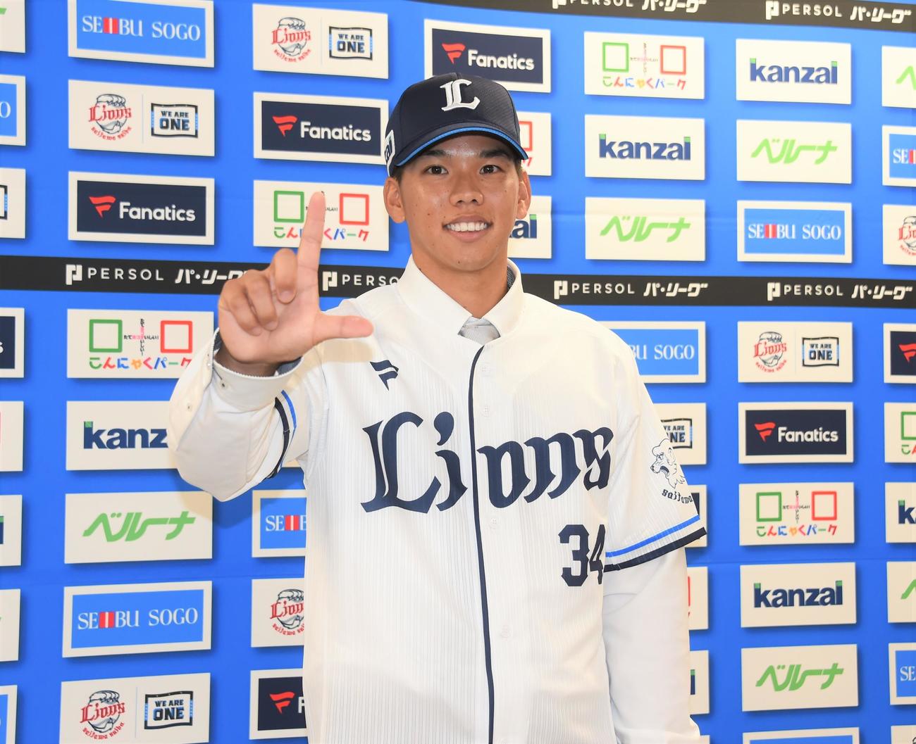 西武にトレードで中日から加入した高松はユニホーム姿でLポーズを決める（撮影・鈴木正章）