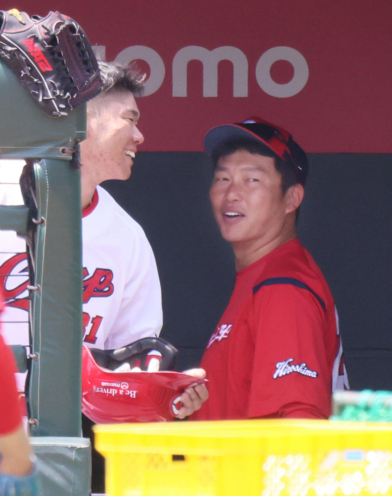 ベンチ内で坂倉（左）と談笑する新井監督（撮影・加藤孝規）