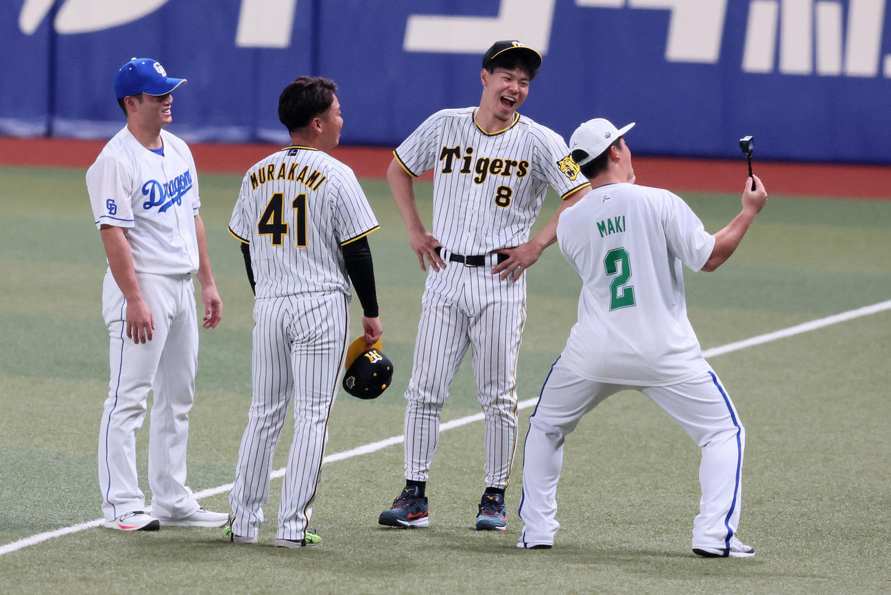 19日、オールスター第1戦で動画撮影する牧（右）に笑顔を見せる佐藤輝ら。左端は細川、同2人目は村上