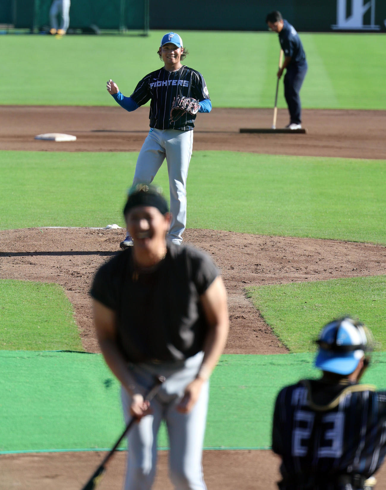 新庄剛志監督（手前）に投げ込み笑顔を見せる日本ハム伊藤大海（撮影・藤尾明華）