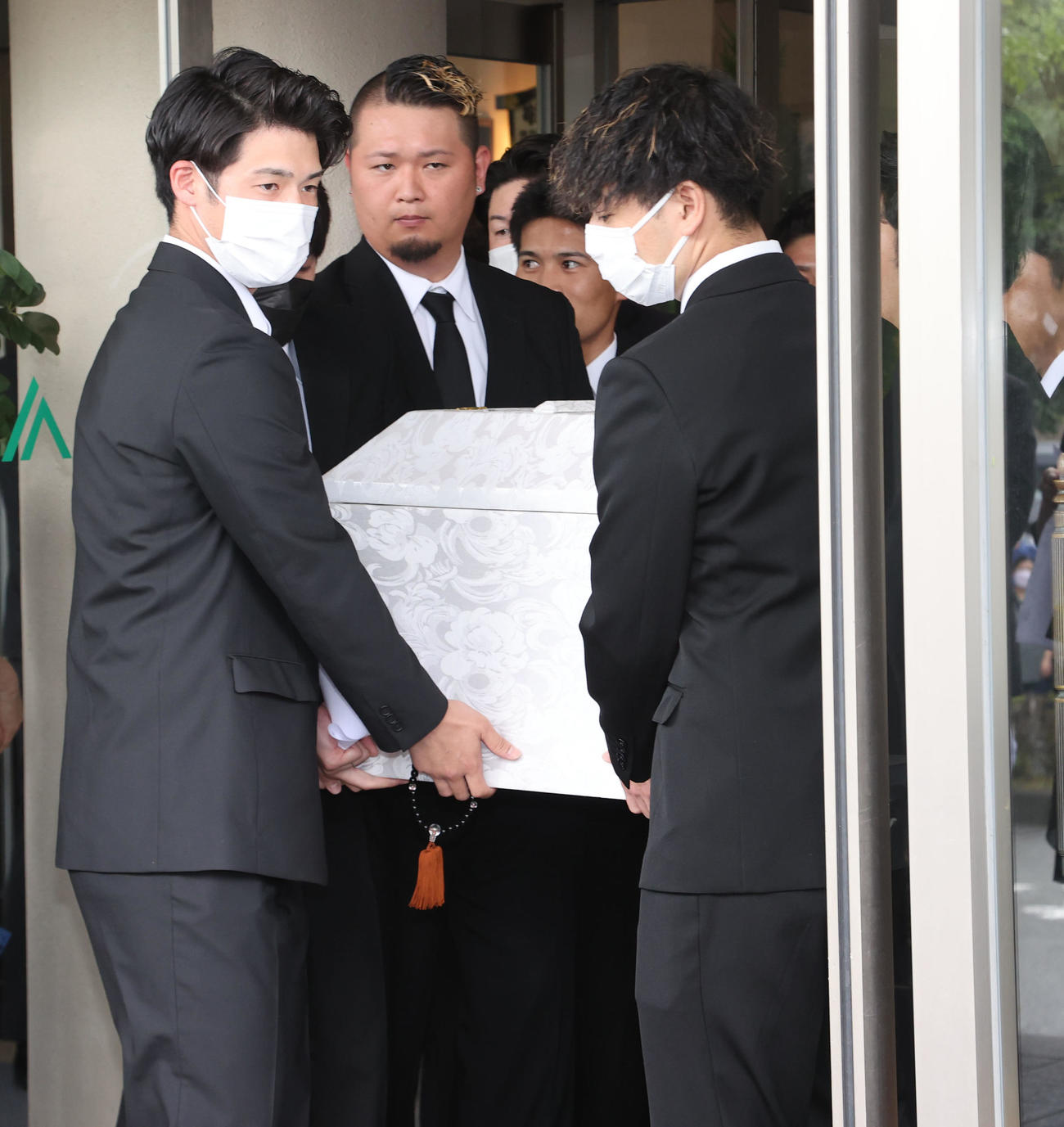 親しい友人らに支えられ葬儀場を出る故・横田氏（撮影・梅根麻紀）