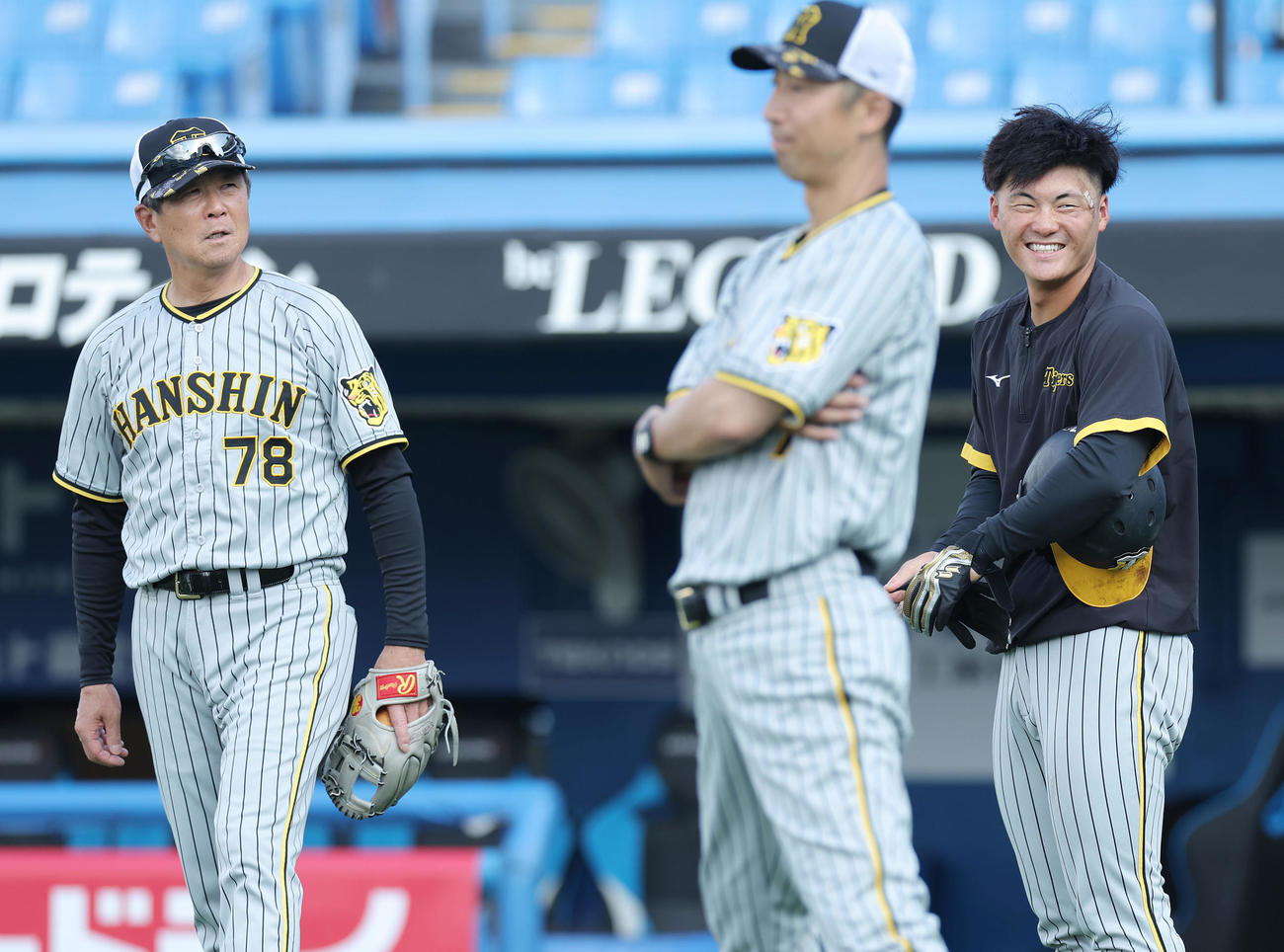 ヤクルト対阪神　流血した左目付近を治療し、平田ヘッドコーチ（左）と言葉を交わして笑顔を見せる阪神前川（撮影・前田充）