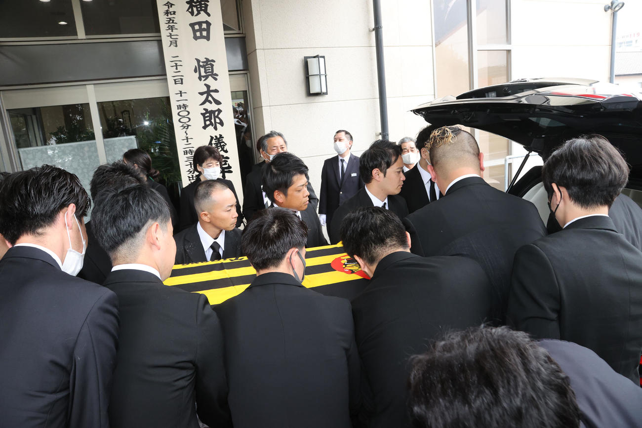 親しい友人らに支えられ葬儀場を出る故・横田氏（撮影・梅根麻紀）