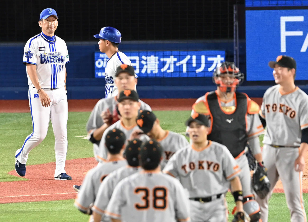 DeNA対巨人　DeNA三浦監督（後方左）は勝利を喜ぶ巨人の選手たちを見つめる（撮影・山崎安昭）