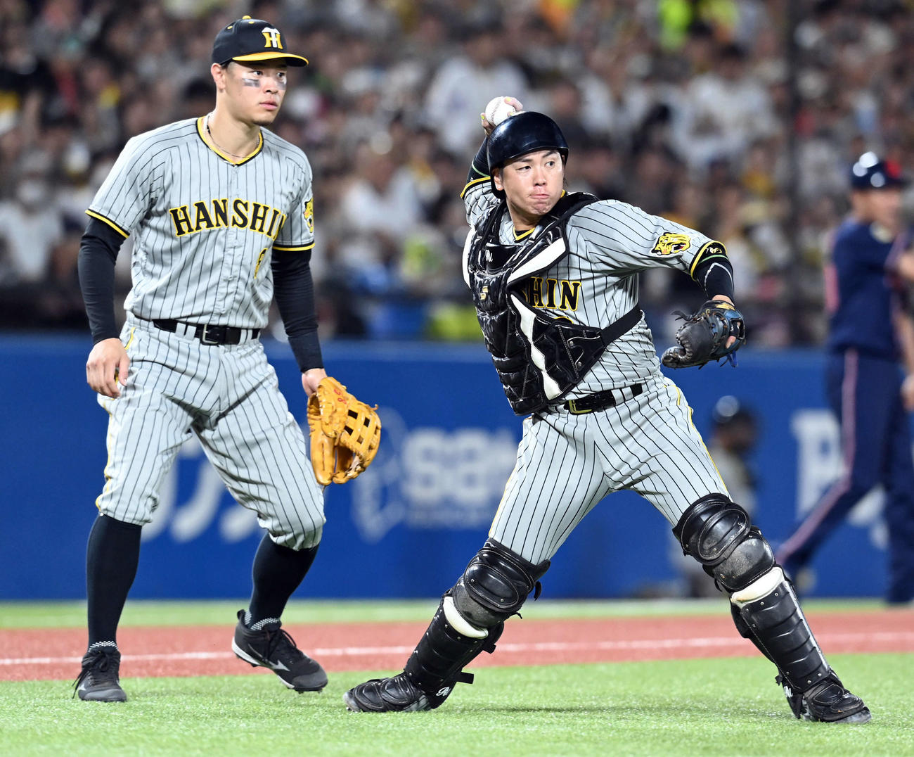 ヤクルト対阪神　5回裏ヤクルト無死一塁、武岡の犠補を処理する梅野。左は佐藤輝（撮影・たえ見朱実）