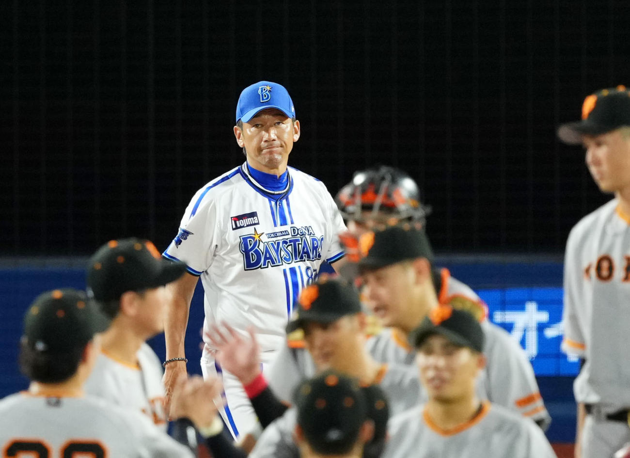 DeNA対巨人　巨人に敗れ険しい表情でスコアを見つめるDeNA三浦監督（奥）（撮影・横山健太）