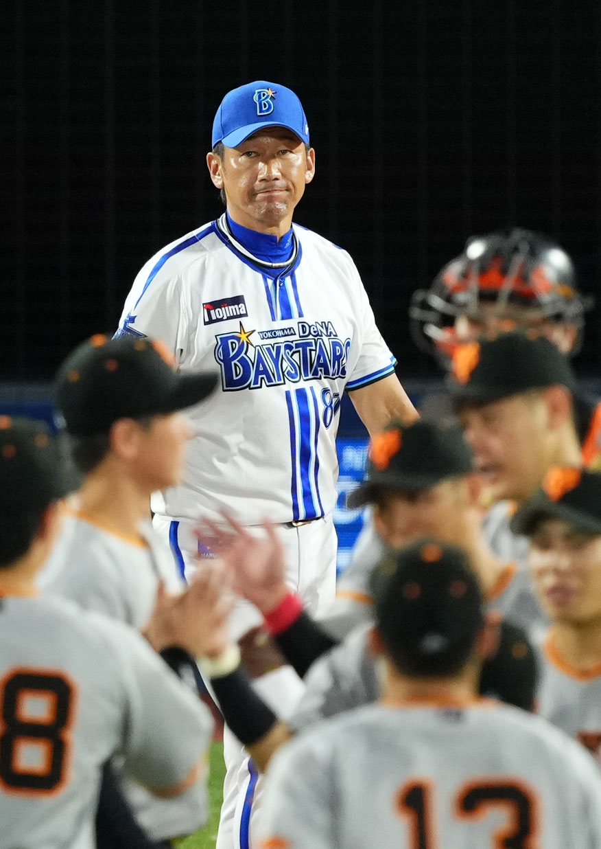 DeNA対巨人　巨人に敗れ険しい表情でスコアを見つめるDeNA三浦監督（奥）（撮影・横山健太）