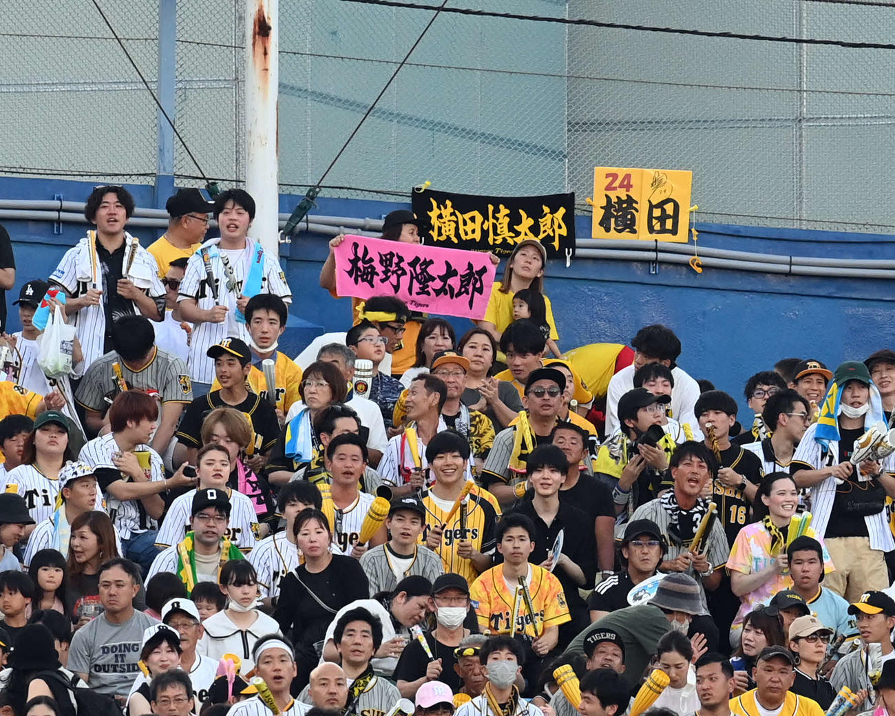 ヤクルト対阪神　横田慎太郎さんのタオルを背に梅野のタオルを掲げるファン（撮影・たえ見朱実）