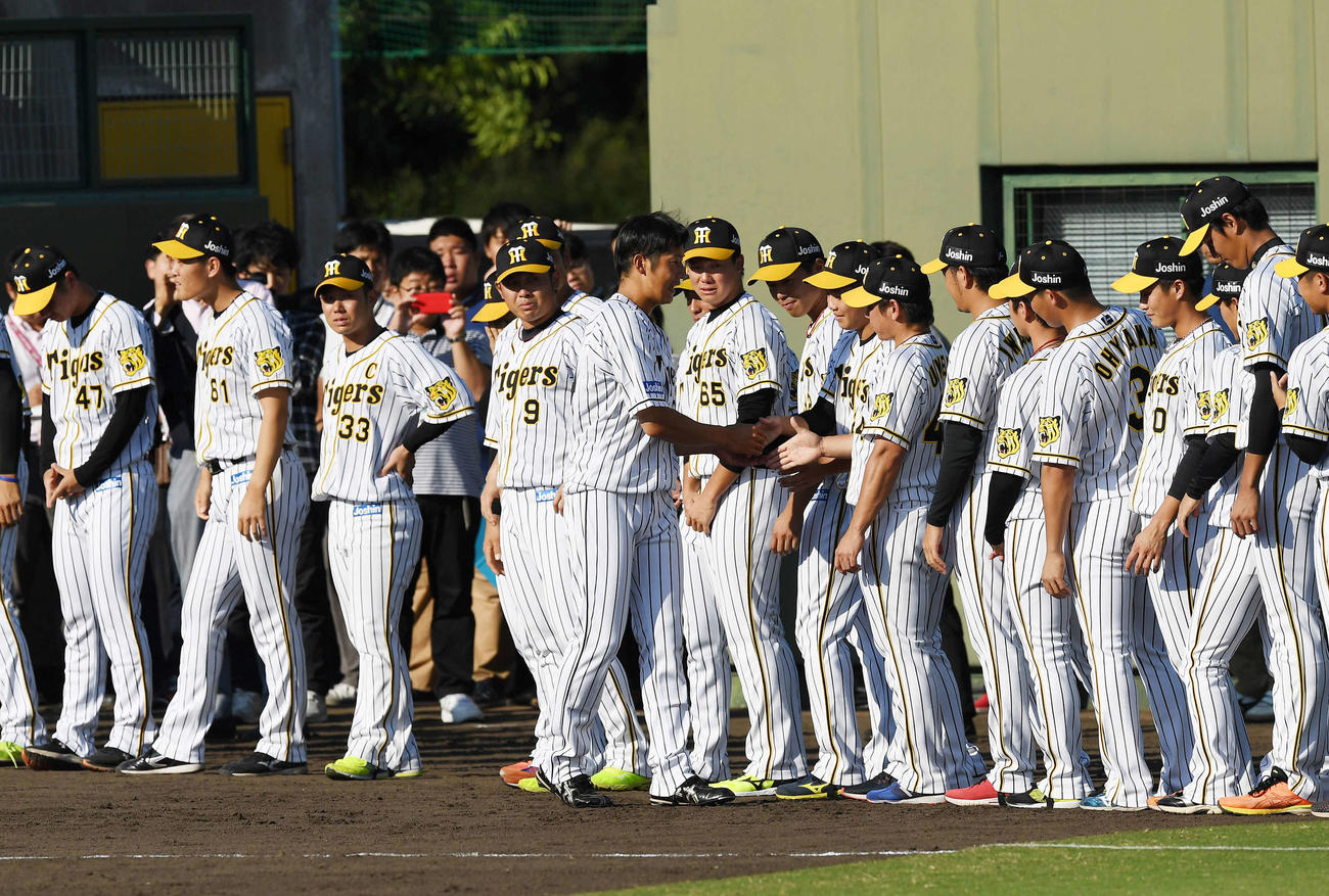 19年9月26日、引退セレモニーで阪神ナインと握手を交わす横田慎太郎さん（中央）