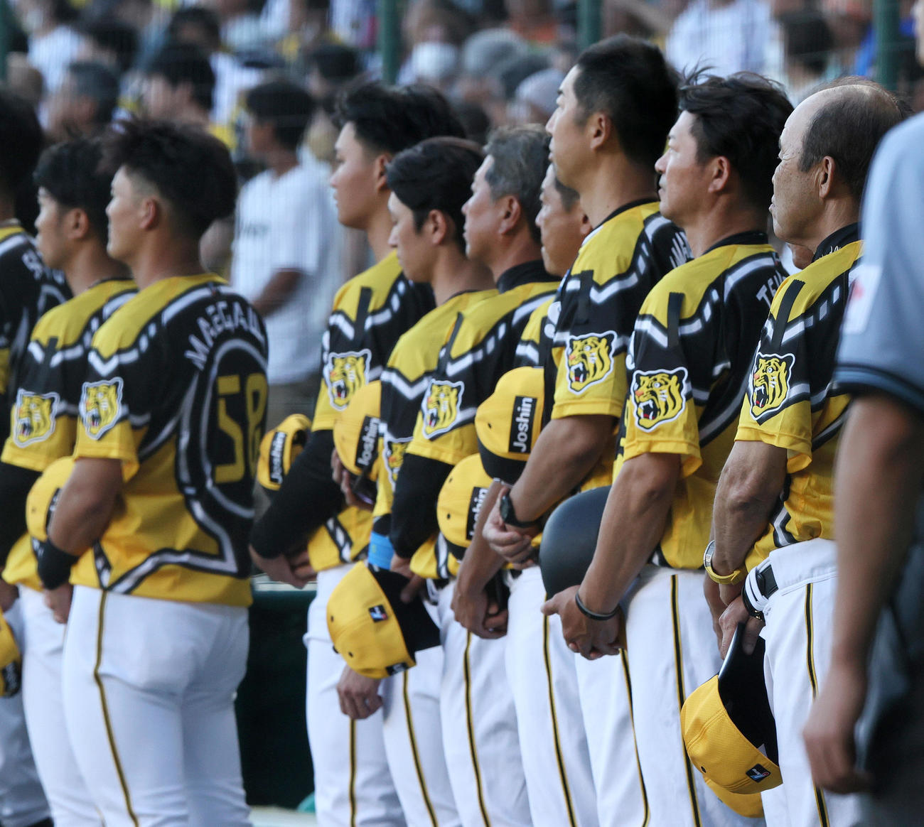 阪神対巨人　故・横田慎太郎さんをしのんで喪章をつける阪神岡田監督（右）らナイン（撮影・上山淳一）