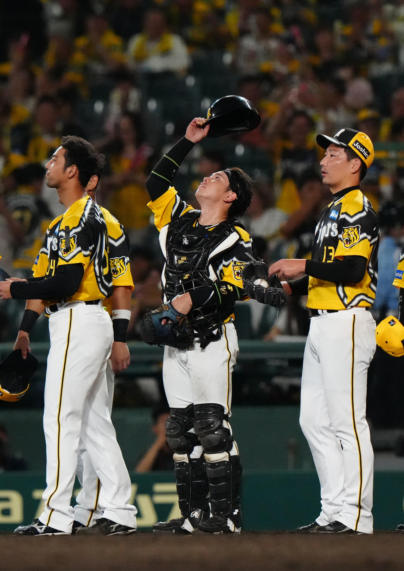 阪神対巨人　試合後、天を見上げる阪神捕手梅野（中央）。右は最後を締めた岩崎（撮影・江口和貴）