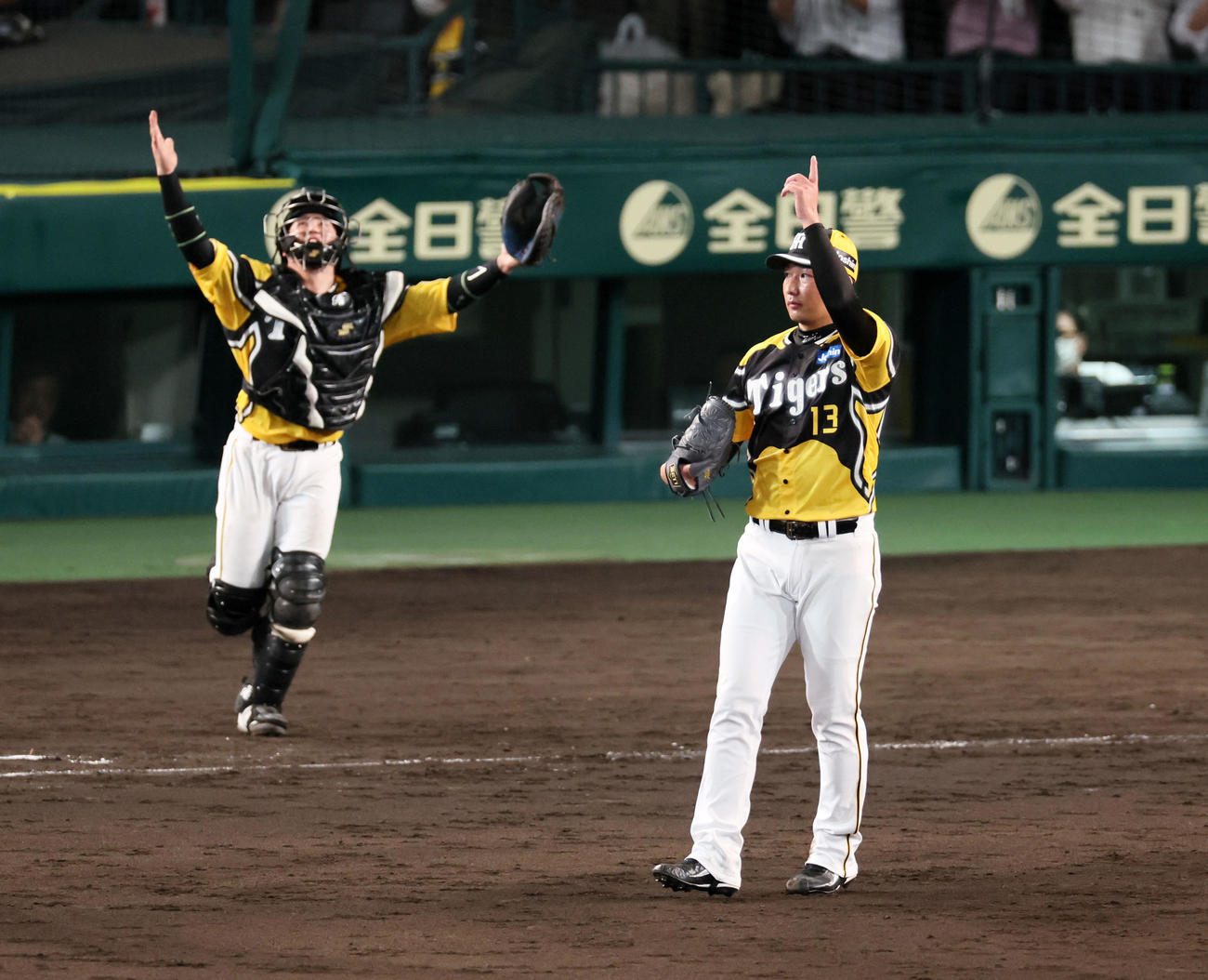 阪神対巨人　9回表巨人2死、岩崎は代打長野を二ゴロに仕留めて勝利し、天を指さす。左は梅野（撮影・加藤哉）