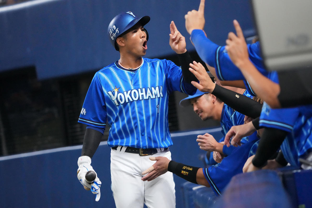 中日対DeNA 1回表DeNA無死一、三塁、宮崎の左前適時打で生還しナインとタッチを交わす桑原（左）（撮影・森本幸一）