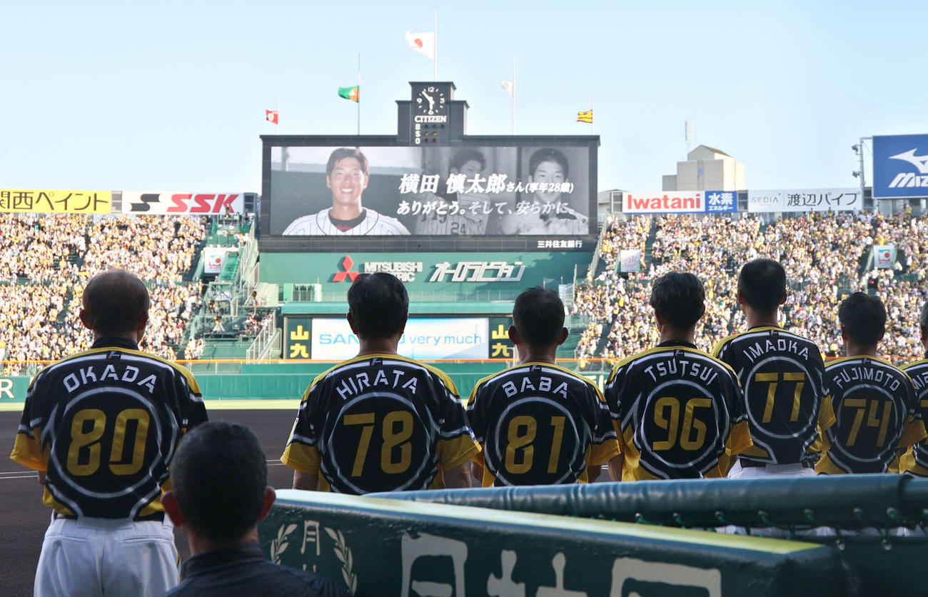 阪神対巨人　スコアボードに流れる横田慎太郎さんの追悼映像を見つめる岡田監督（左）ら阪神ナイン（撮影・上山淳一）