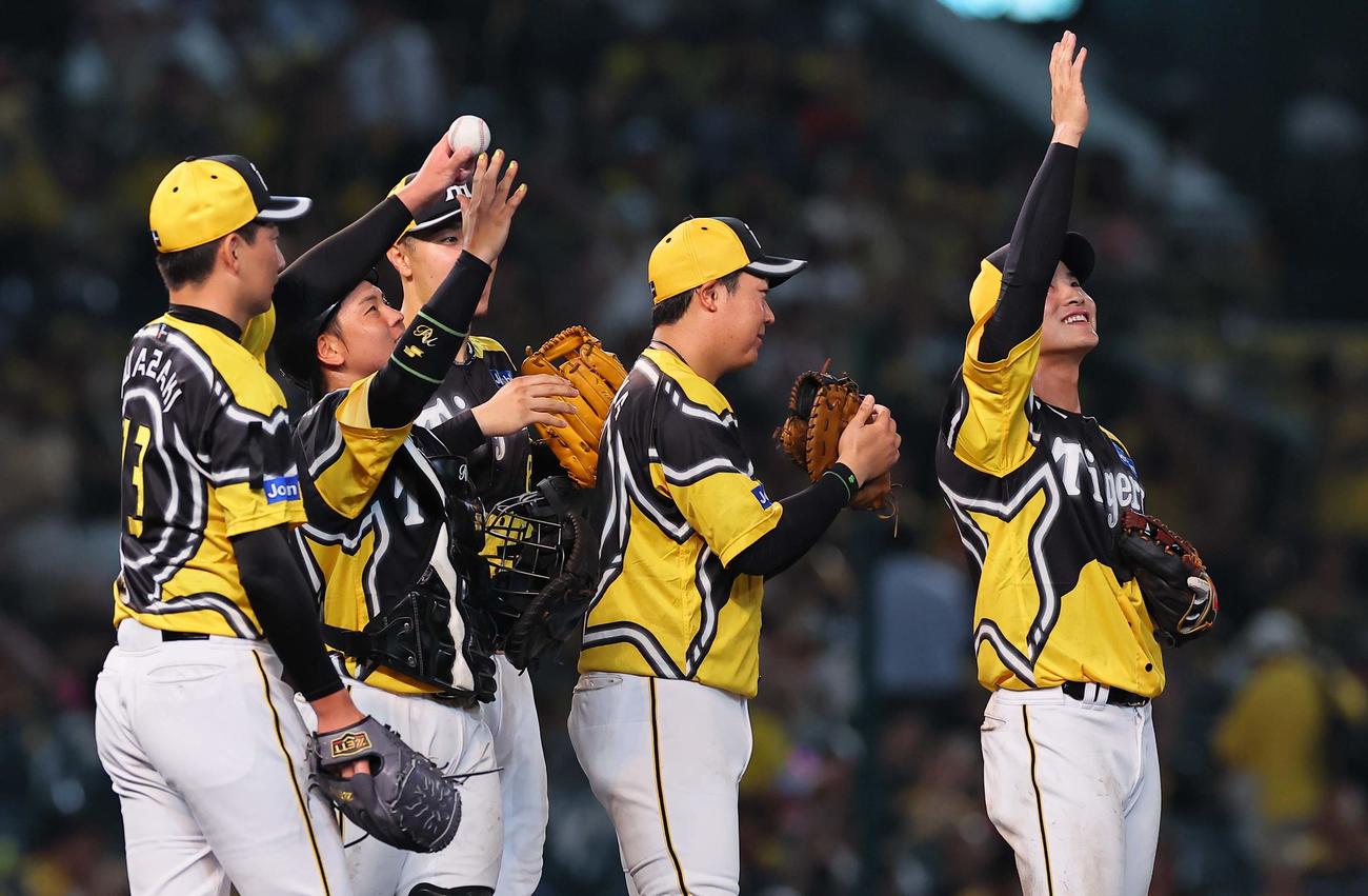 阪神対巨人　勝利球を高々と上げる岩崎。梅野（左から2人目）と木浪も空に手を上げる（撮影・上田博志）