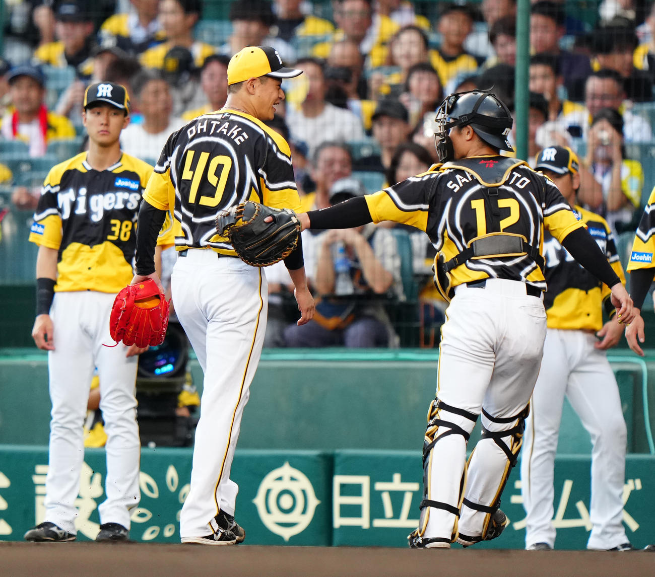 阪神対巨人　1回表終了後、阪神捕手坂本（右）に言葉をかけられ、笑顔を見せる先発の大竹（撮影・江口和貴）