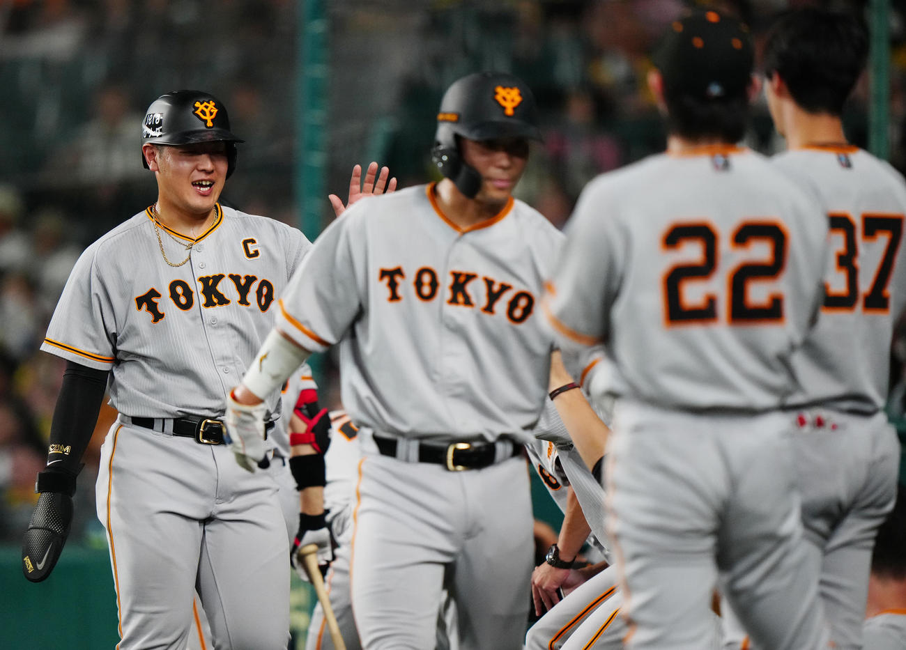 阪神対巨人　6回表巨人2死一、二塁、長野の2点適時二塁打で生還し、タッチを交わす岡本和（左端）（撮影・江口和貴）