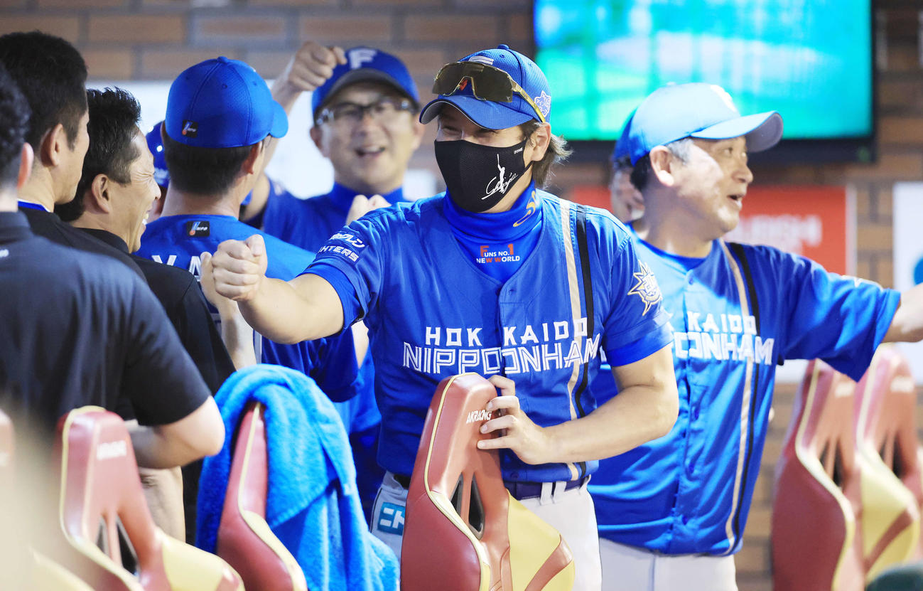 楽天対日本ハム　連敗を13でストップし、笑顔でコーチ陣らとグータッチで喜ぶ新庄監督笑顔（中央）（撮影・浅見桂子）