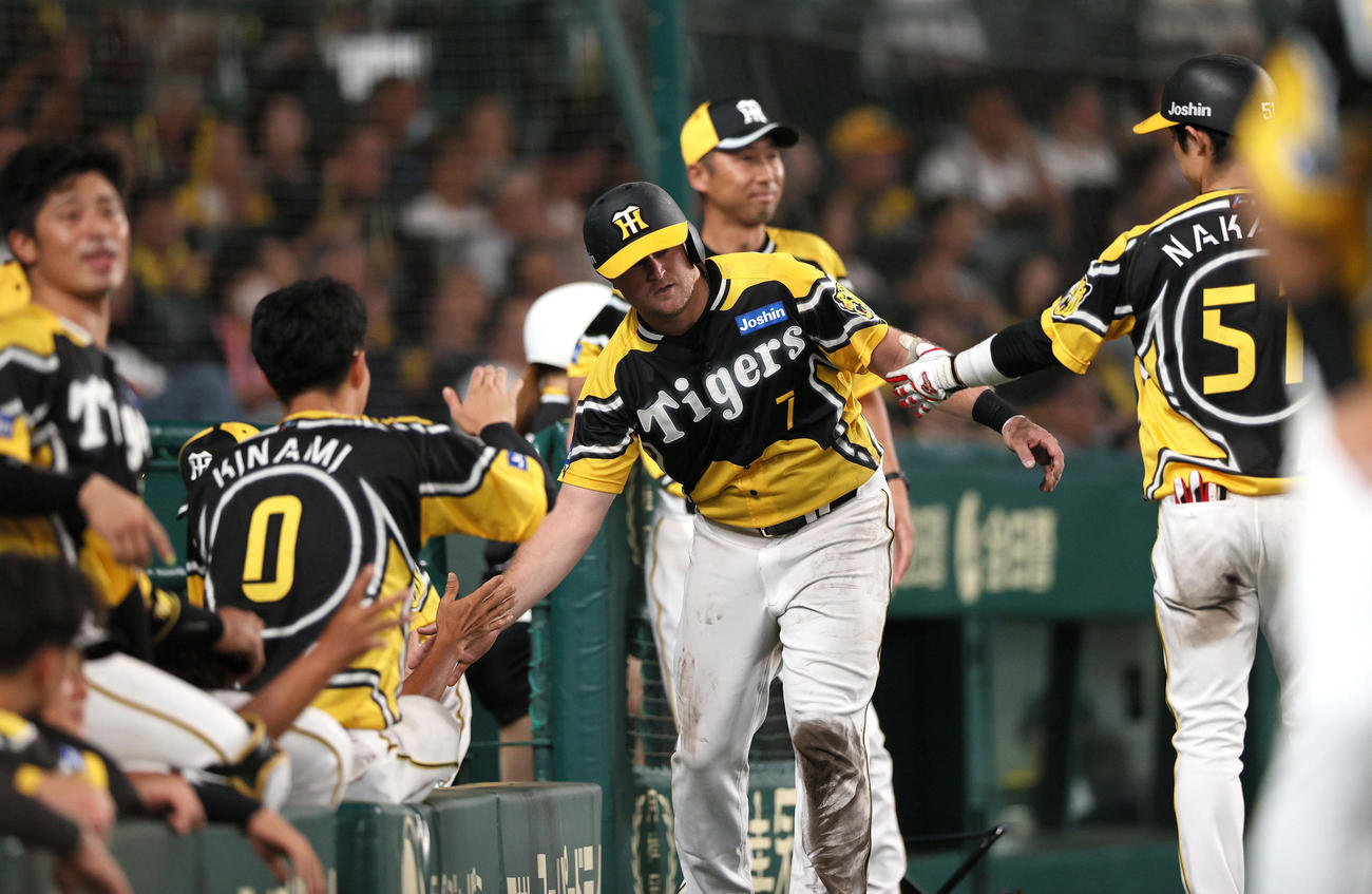 阪神対巨人　6回裏阪神2死一、二塁、ノイジー（右から2人目）は代打原口の左前適時打で生還し、出迎えを受ける（撮影・上山淳一）