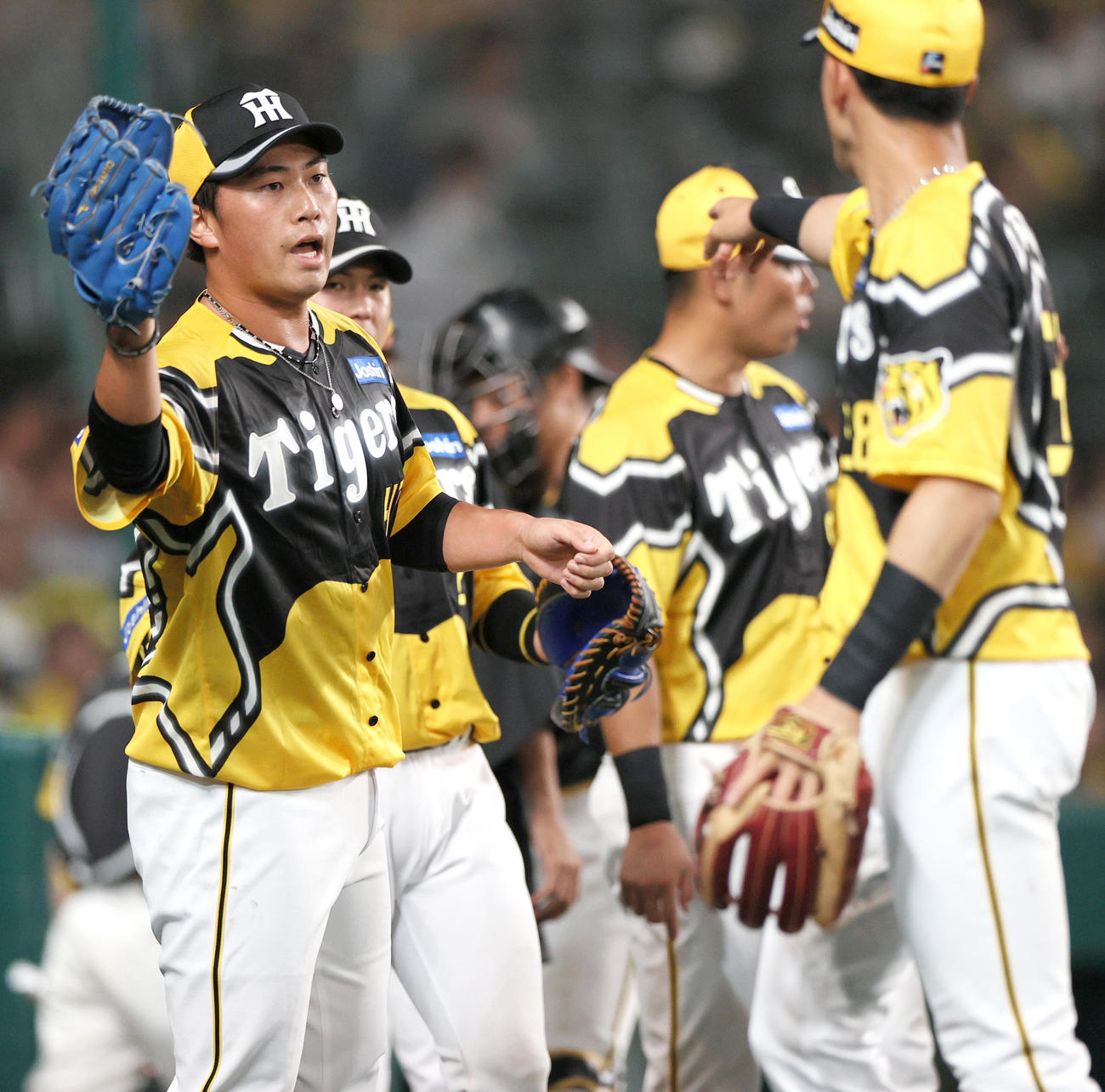 阪神対巨人　7回表を無失点に抑えた桐敷（左）はベンチ前で野手を迎える（撮影・上山淳一）