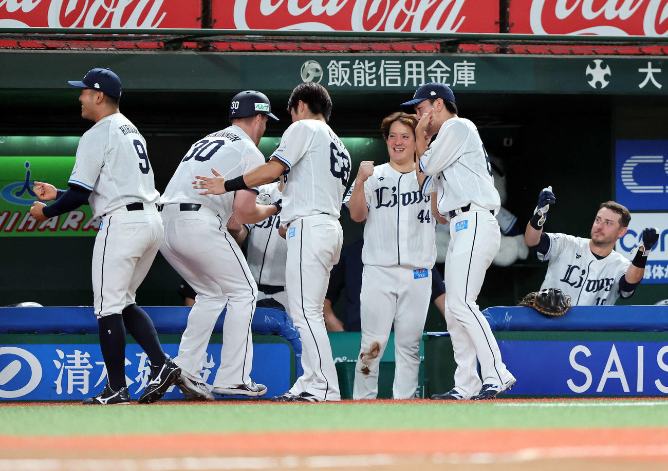西武対ロッテ　6回裏西武1死二塁、マキノン（左から2人目）の左越え2点本塁打をガッツポーズで迎える与座（中央）（撮影・鈴木正人）