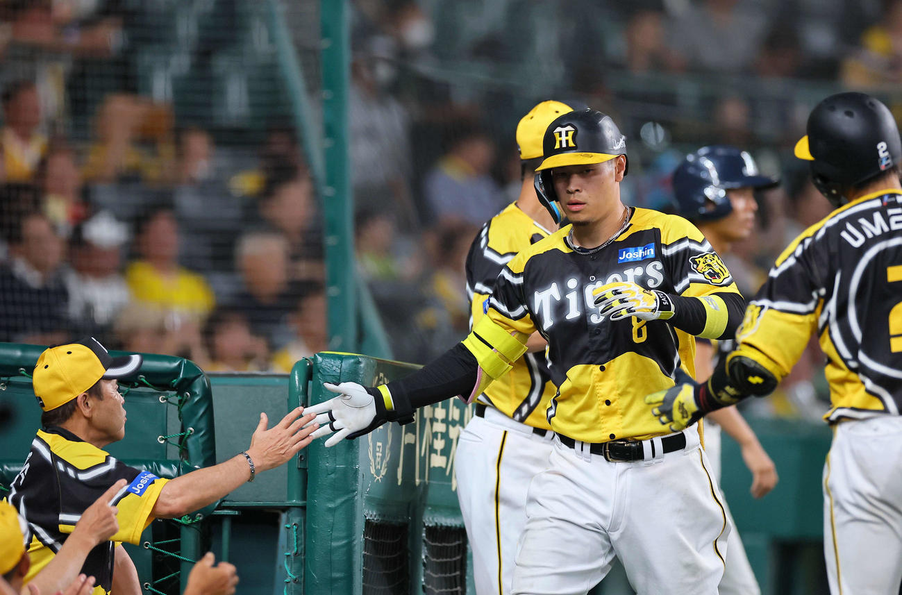 阪神対巨人　8回裏阪神無死、中越えソロ本塁打を放った佐藤輝は岡田監督（左）とハイタッチをする（撮影・上田博志）