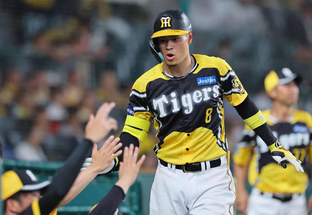 阪神対巨人　8回裏阪神無死、佐藤輝は中越えソロ本塁打を放ちナインとハイタッチをする（撮影・上田博志）