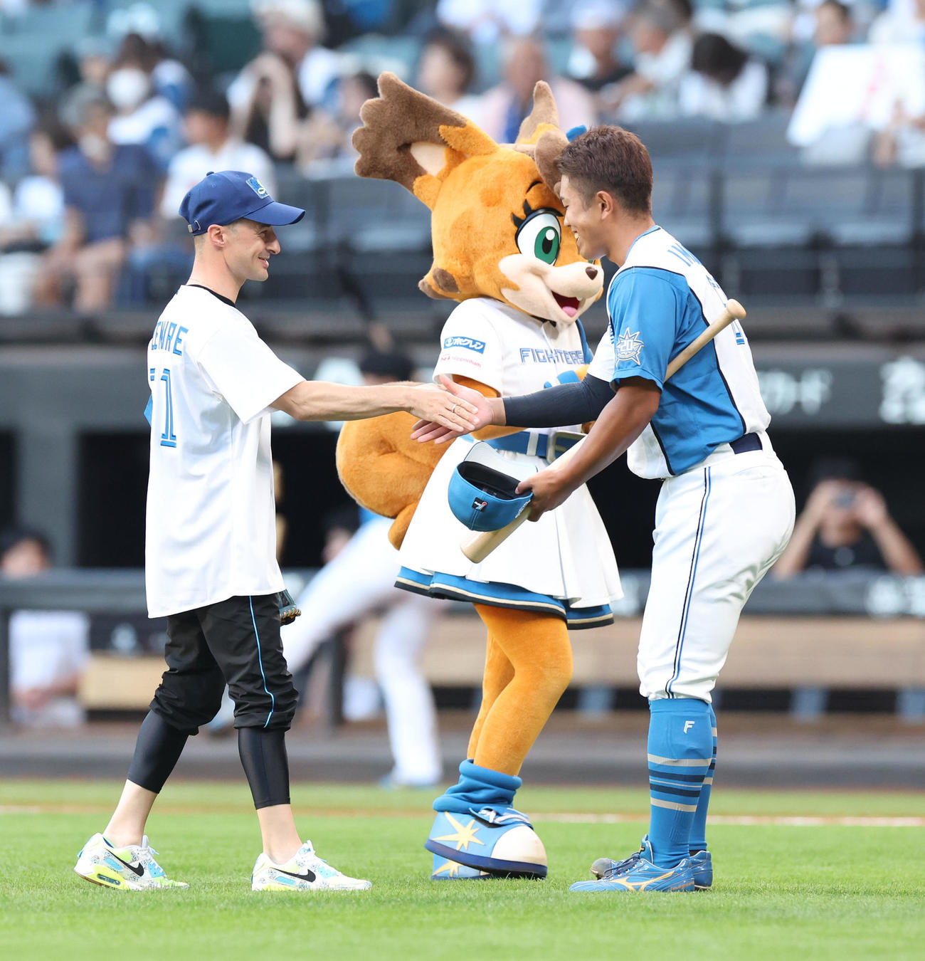 日本ハム対オリックス　試合前、ファーストピッチを務めルメール騎手（左）は今川と握手する（撮影・佐藤翔太）