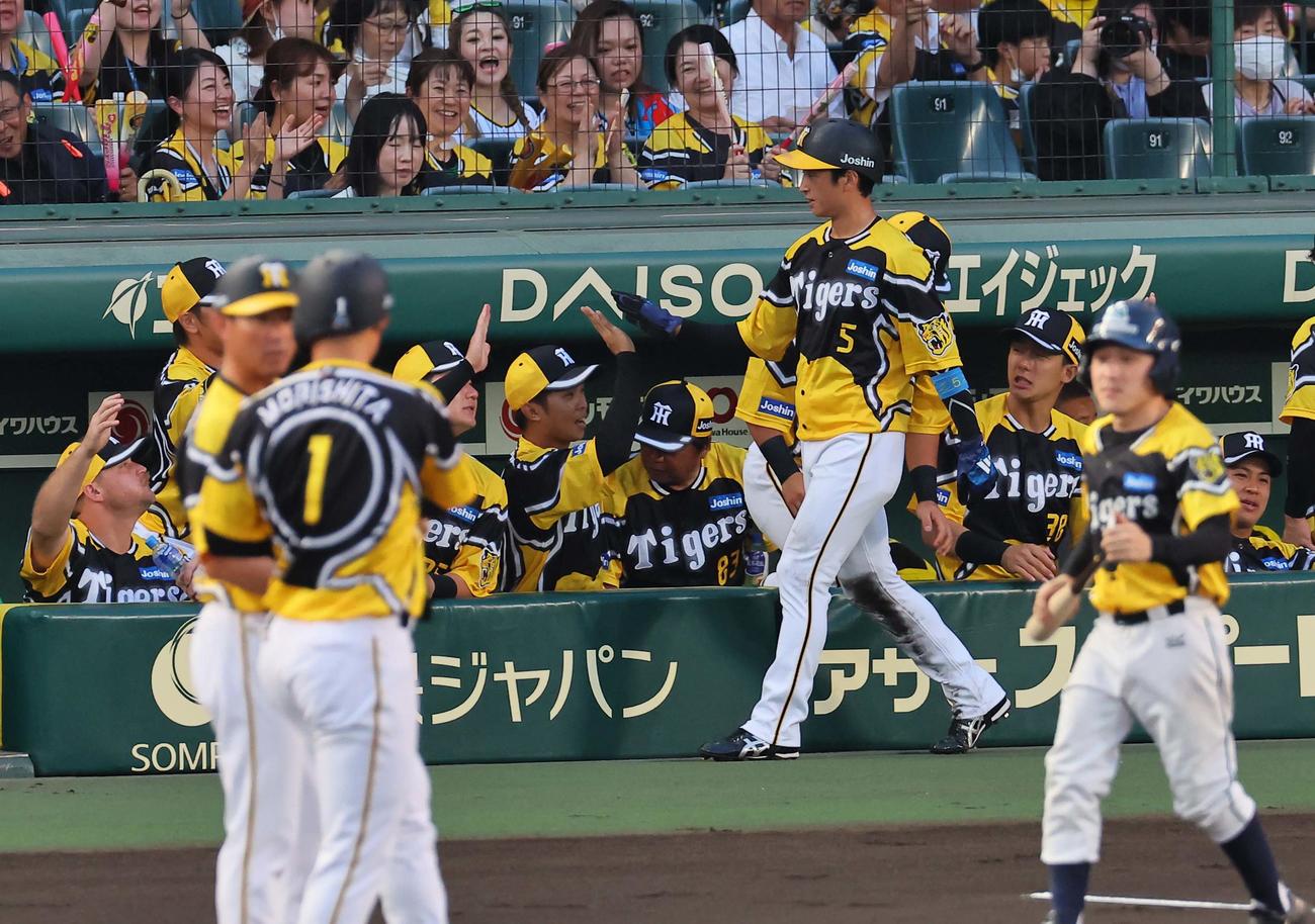 阪神対広島　1回裏阪神1死二塁、森下翔太（左手前）の中前先制適時打で生還した近本光司を出迎える阪神ナイン（撮影・上田博志）