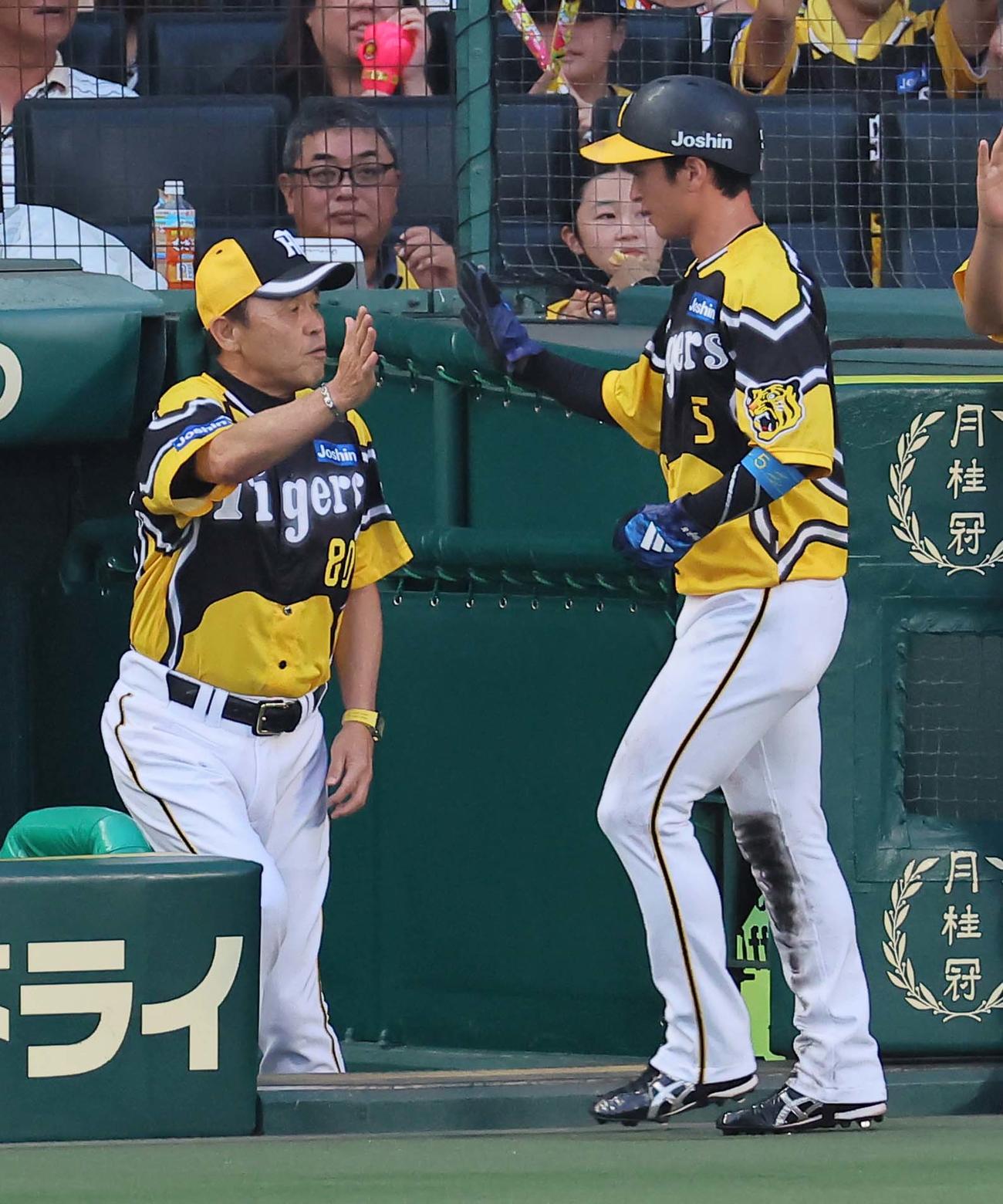 阪神対広島　1回裏阪神1死二塁、岡田監督（左）は森下の中前先制適時打で生還した近本を出迎える（撮影・上田博志）