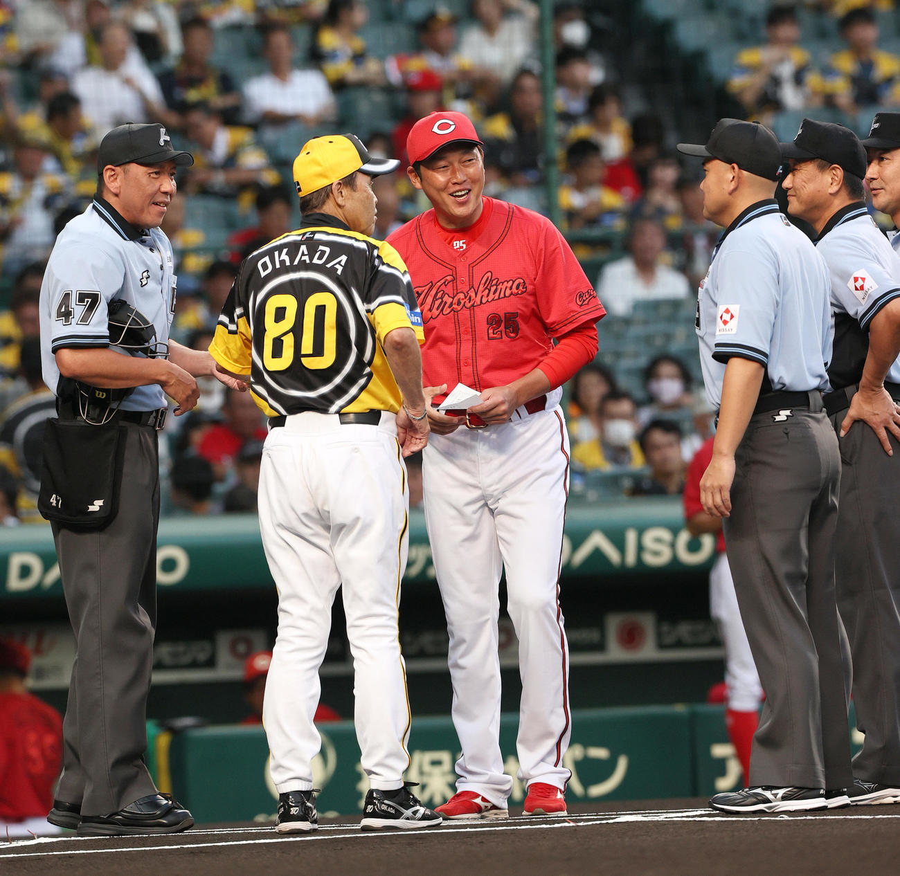 阪神対広島　試合前、阪神岡田彰監督（左から2人目）と広島新井監督がメンバー表を交換する（撮影・上山淳一）