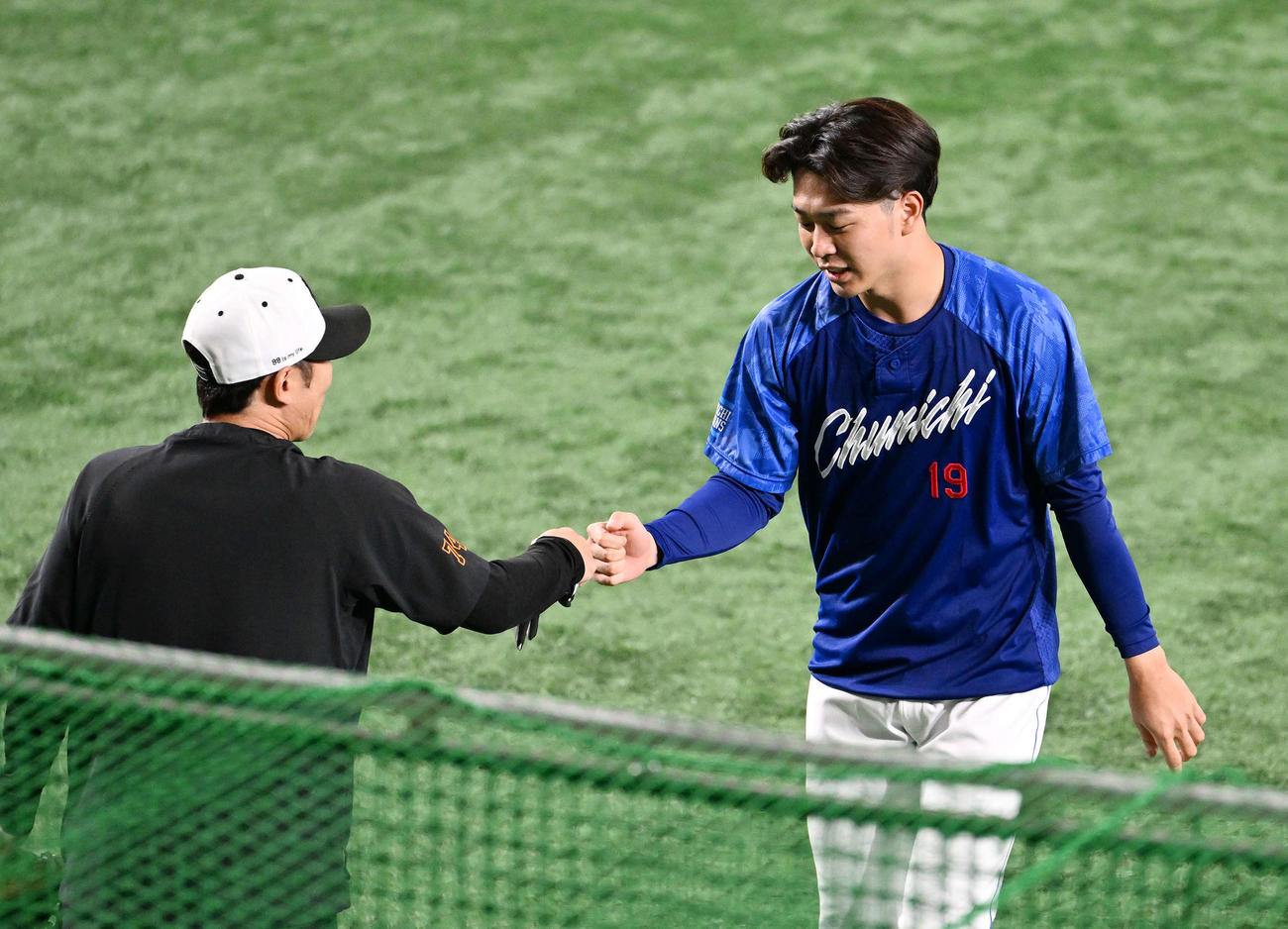 巨人対中日　試合前練習で中日高橋宏（右）は巨人村田ブルペンコーチとタッチをかわす（撮影・滝沢徹郎）