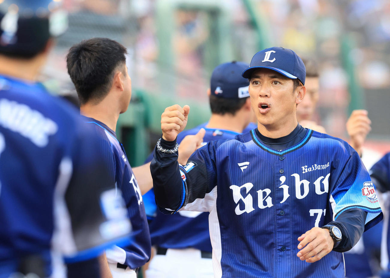 楽天対西武　試合開始前、ナインと気合のグータッチをする西武松井監督（撮影・浅見桂子）