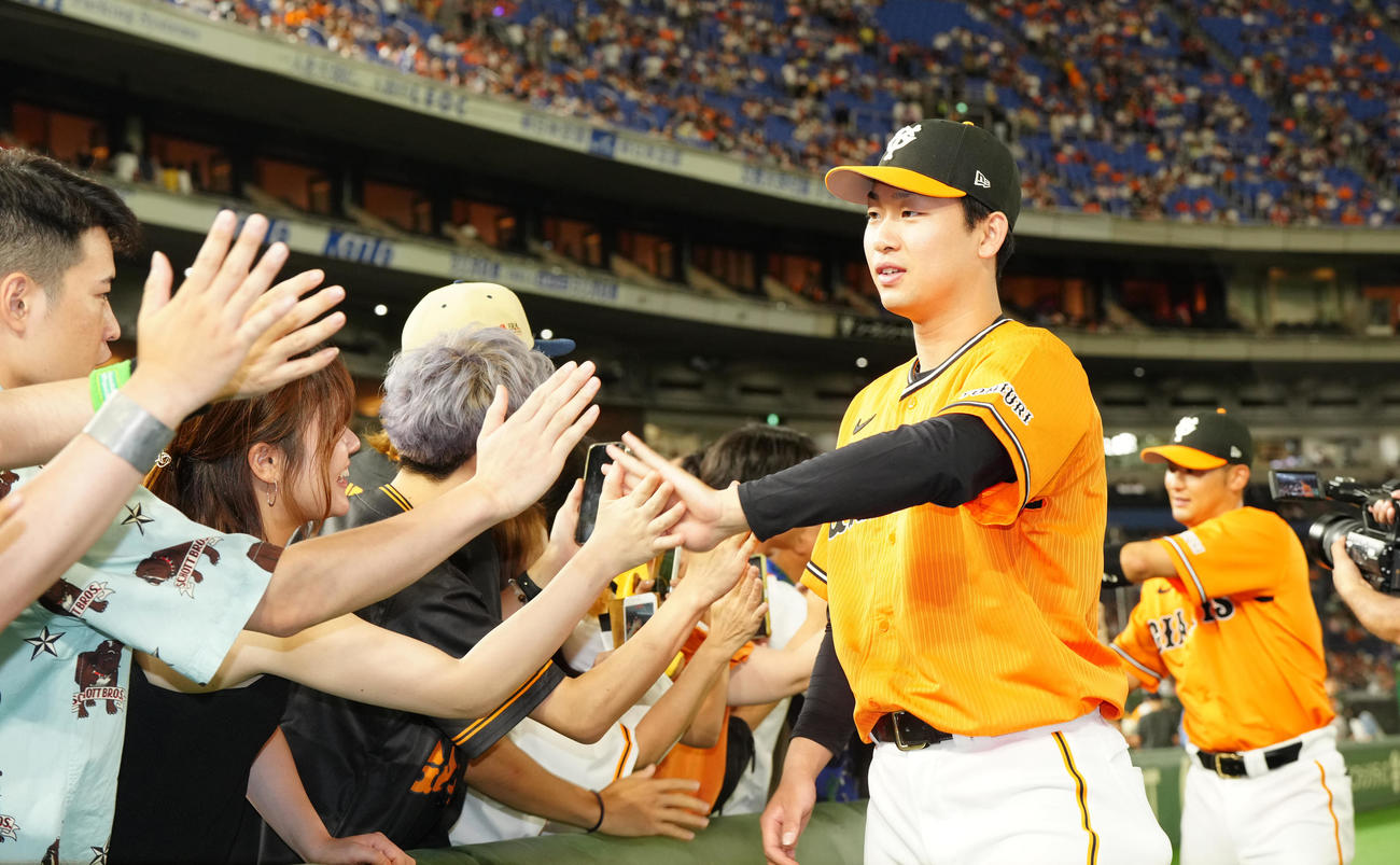 巨人対中日　試合後、ファンとタッチを交わす巨人山崎伊。後方は吉川（撮影・江口和貴）