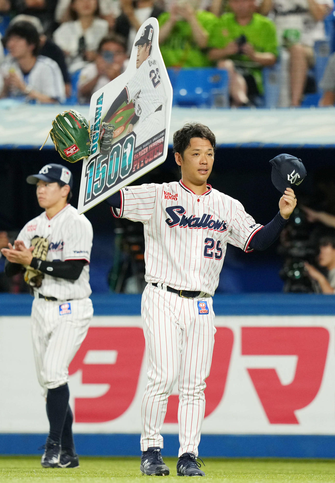 ヤクルト対DeNA 7回表終了時、1500投球回を達成しボードを掲げるヤクルト小川（撮影・横山健太）