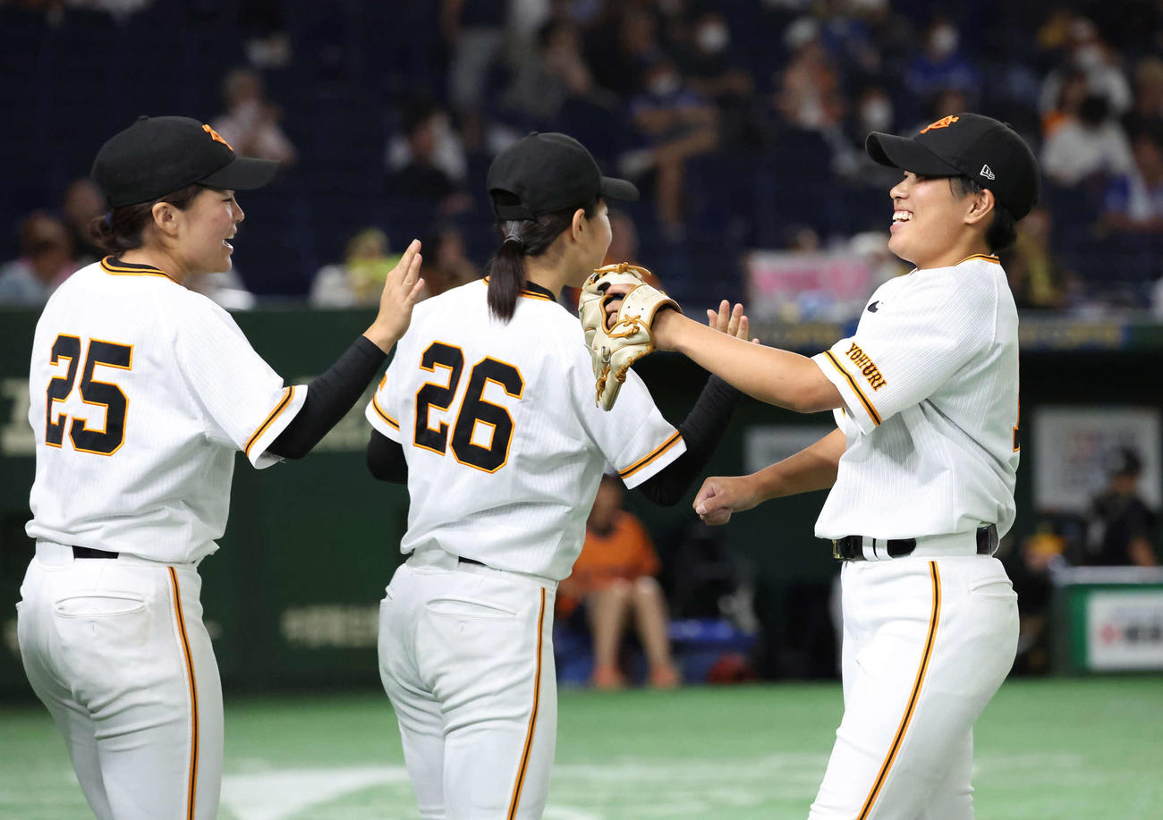 女子野球交流戦　巨人対阪神　4回を投げ終えて、ナインとタッチを交わしてベンチへ戻る巨人先発小野寺（右）（撮影・丹羽敏通）