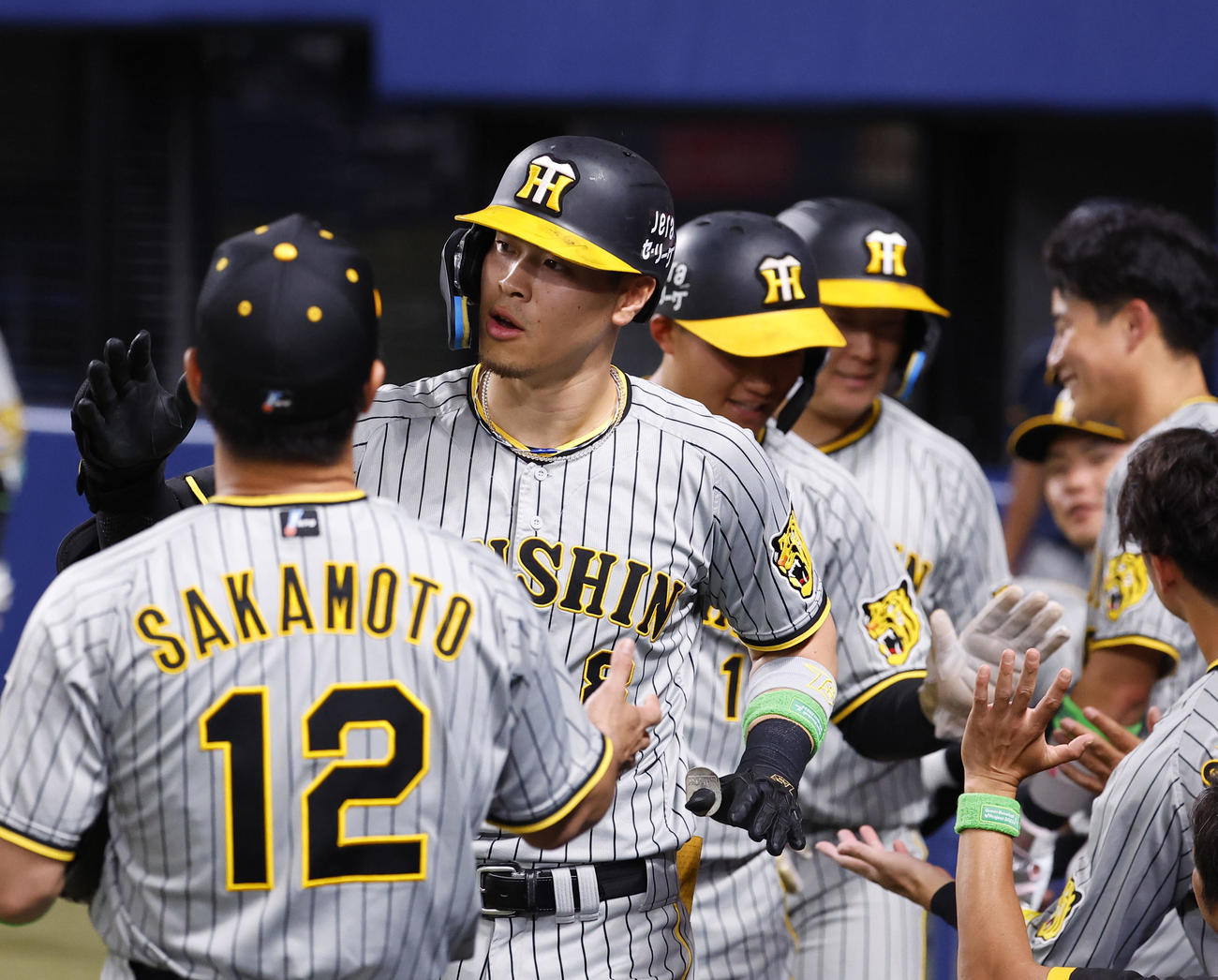 中日対阪神　7回表阪神1死一、二塁、中越えに3点本塁打を放ちナインとタッチを交わす佐藤輝（左から2人目）（撮影・藤尾明華）