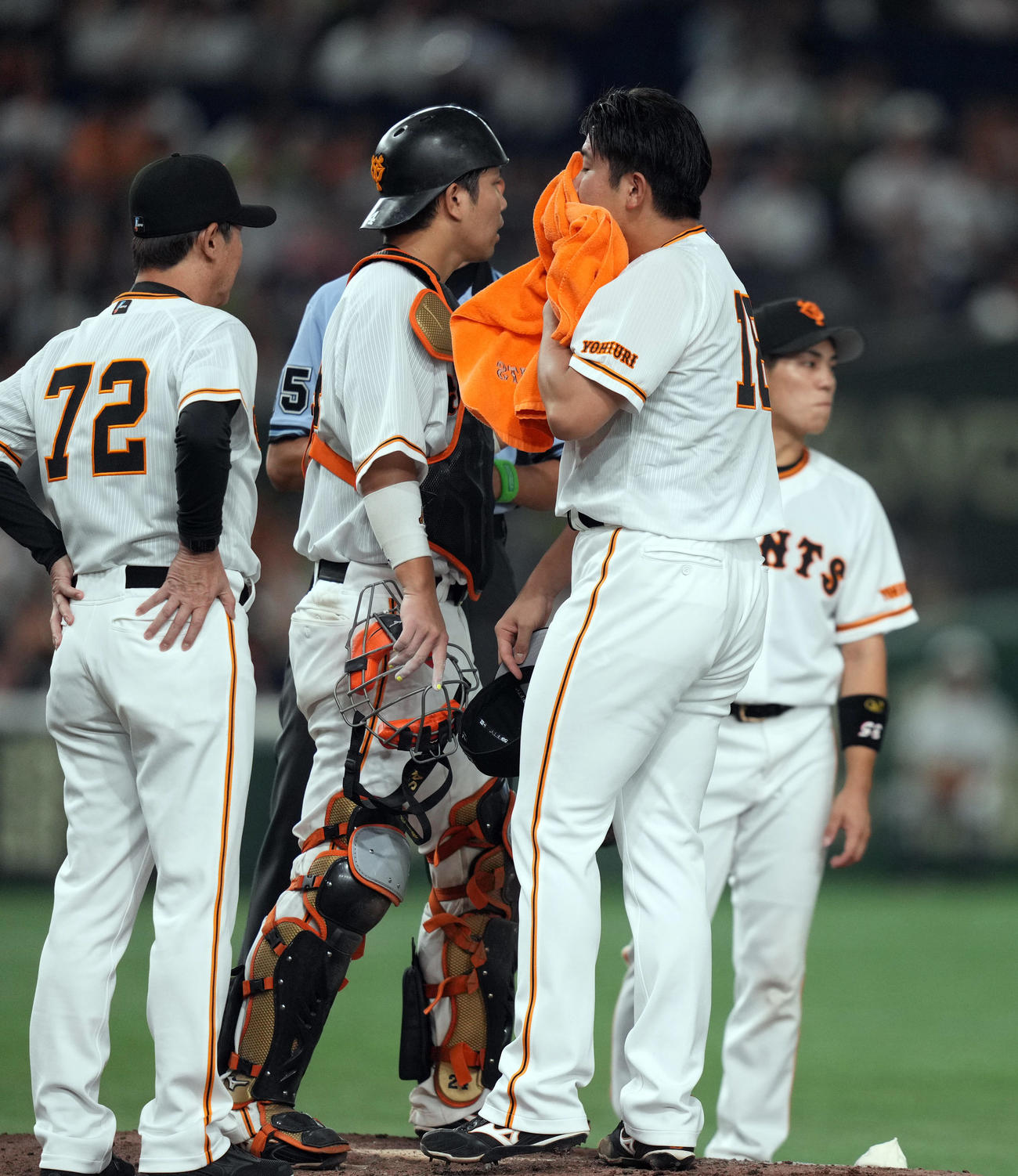 巨人対ヤクルト　7回表ヤクルト1死一、三塁、マウンドで阿波野投手チーフコーチ（左）が持ってきたバスタオルで汗を拭く菅野（右）（撮影・狩俣裕三）